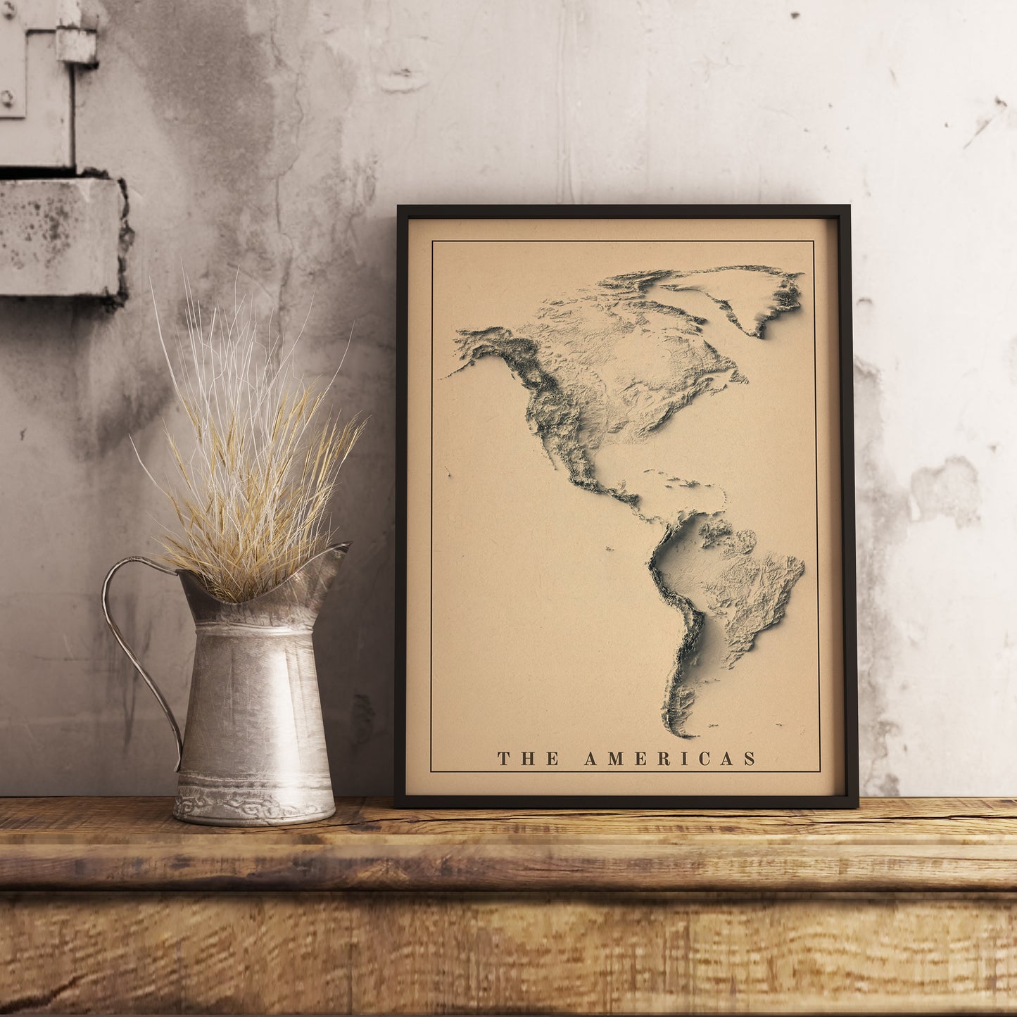 Vintage Americas shaded relief map in black frame. Realistic terrain art print for home decor, displayed on rustic wooden table