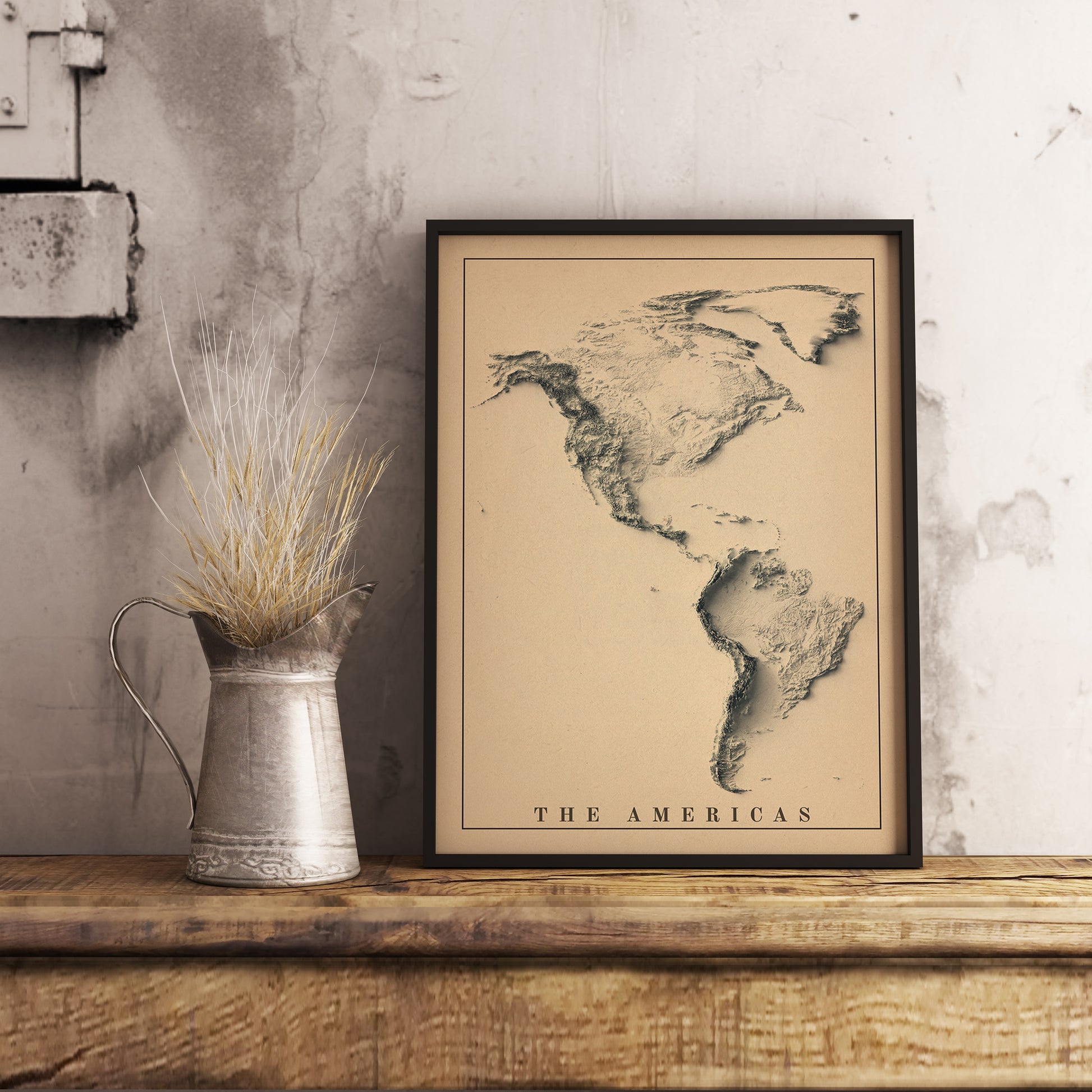 Vintage Americas shaded relief map in black frame. Realistic terrain art print for home decor, displayed on rustic wooden table