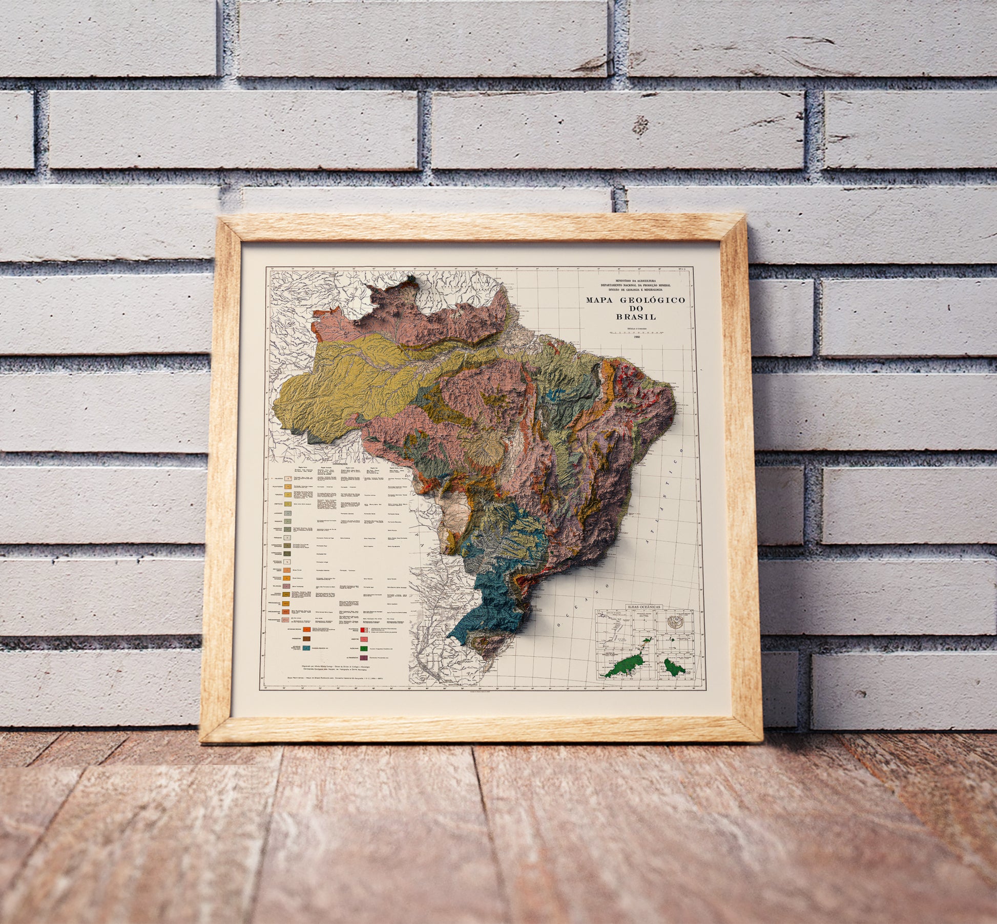 Vintage Brazil shaded relief map in a wooden frame. Realistic terrain art print for home decor, displayed against a brick wall