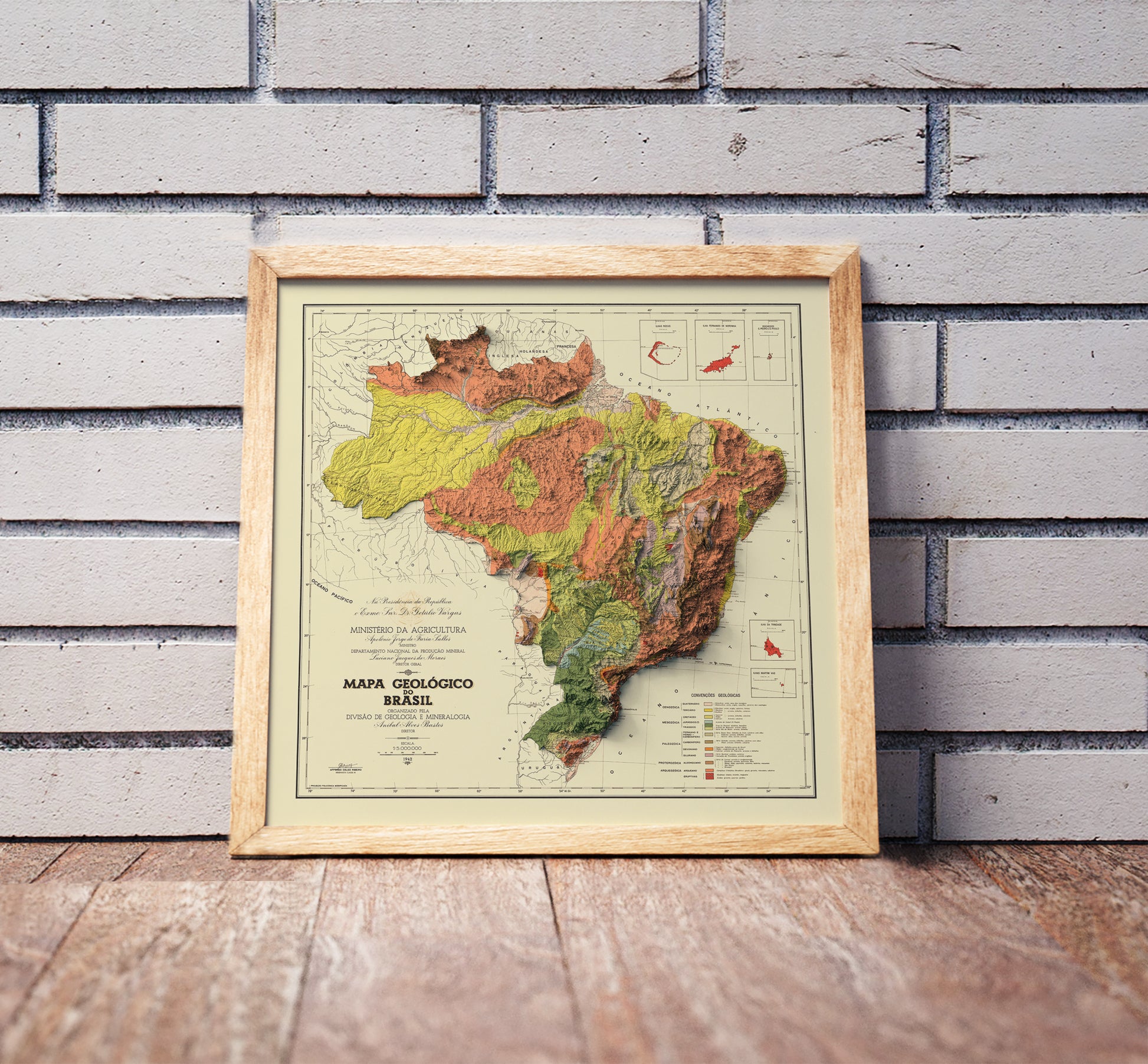 Vintage Brazil shaded relief map in a wooden frame. Realistic terrain art print for home decor, displayed against a brick wall