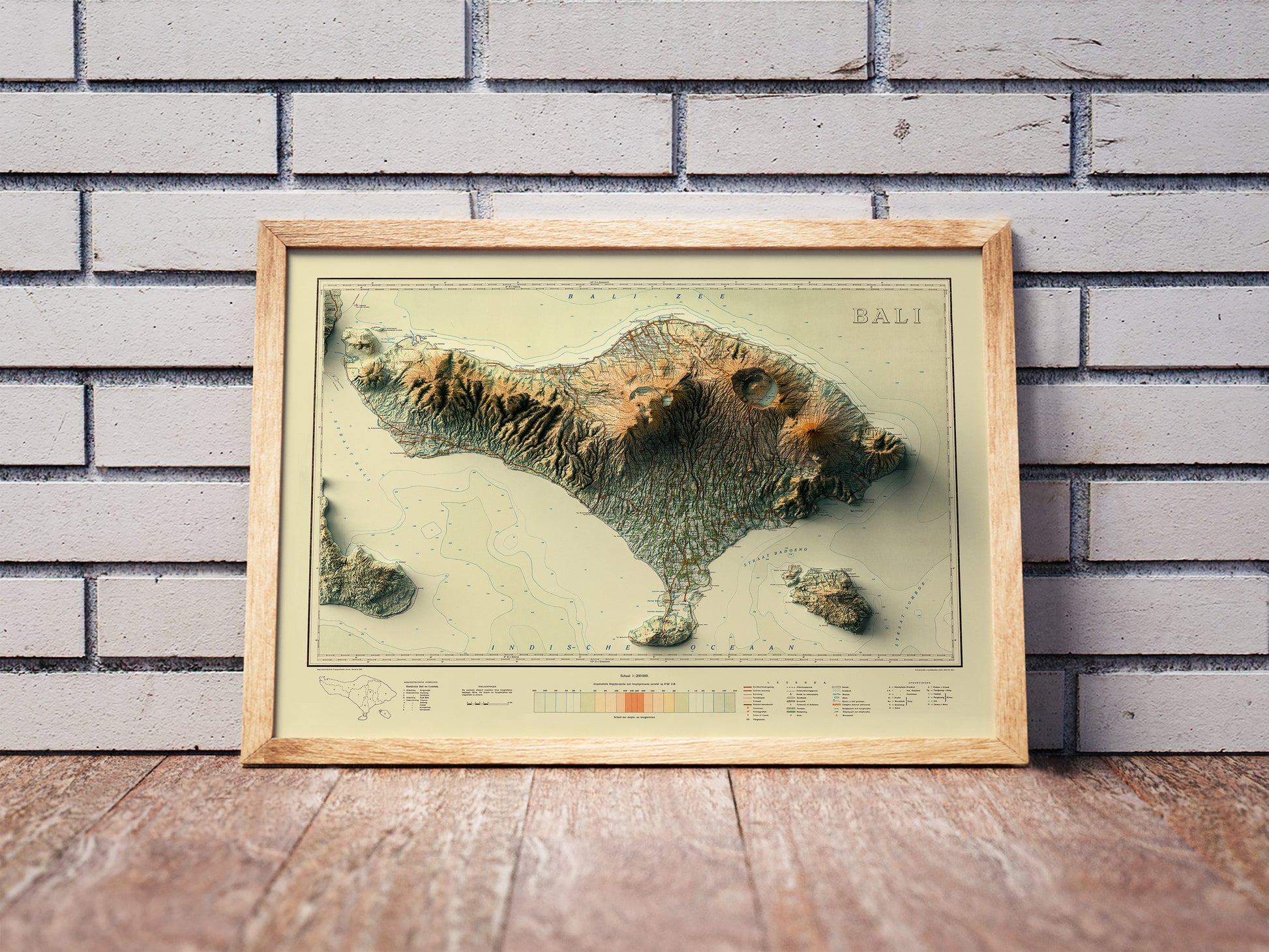 Vintage Bali (Indonesia) shaded relief map in a wooden frame. Realistic terrain art print for home decor, displayed against a brick wall
