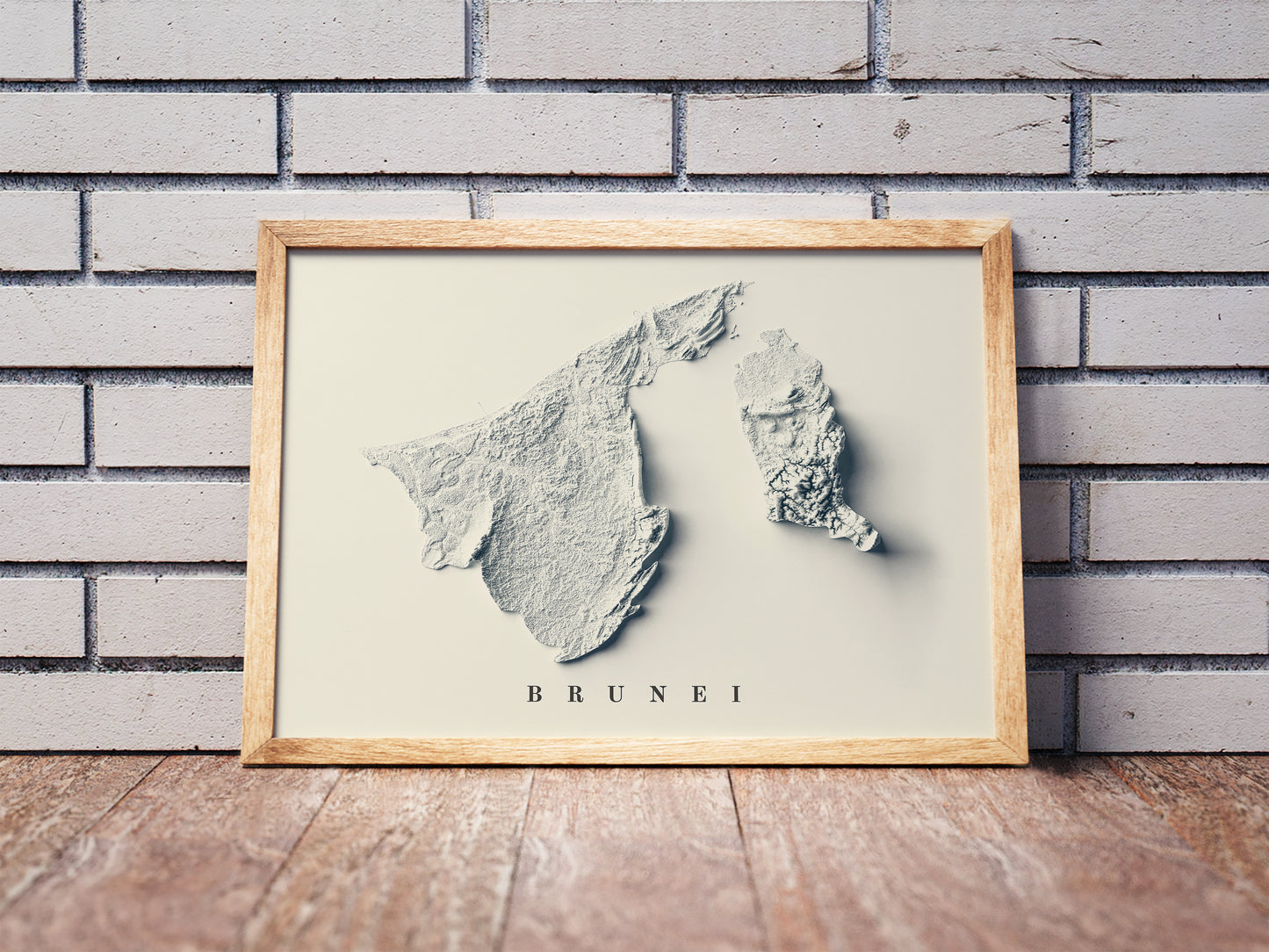 Vintage Brunei shaded relief map in a wooden frame. Realistic terrain art print for home decor, displayed against a brick wall