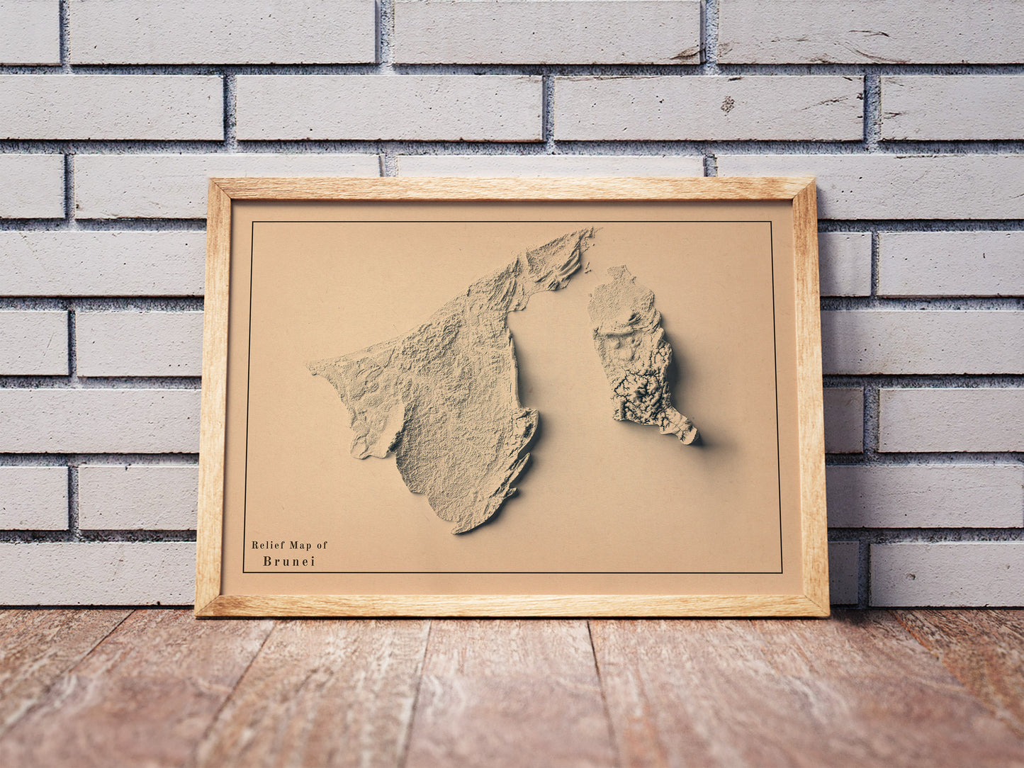Vintage Brunei shaded relief map in a wooden frame. Realistic terrain art print for home decor, displayed against a brick wall