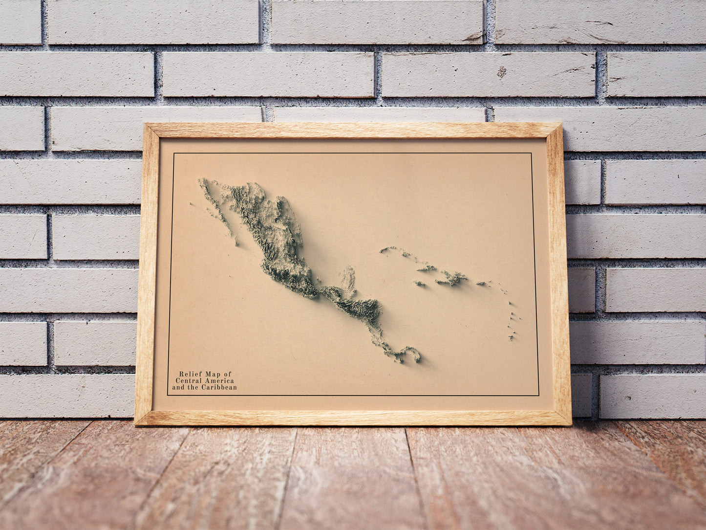 Central America and Caribbean shaded relief map in a wooden frame. Realistic terrain art print for home decor, displayed against a brick wall