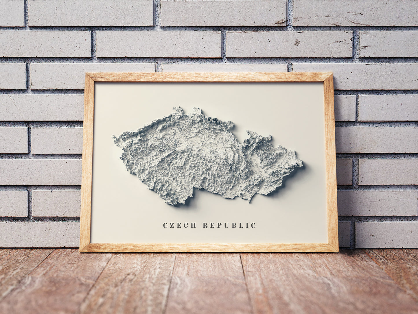 Czech Republic shaded relief map in a wooden frame. Realistic terrain art print for home decor, displayed against a brick wall