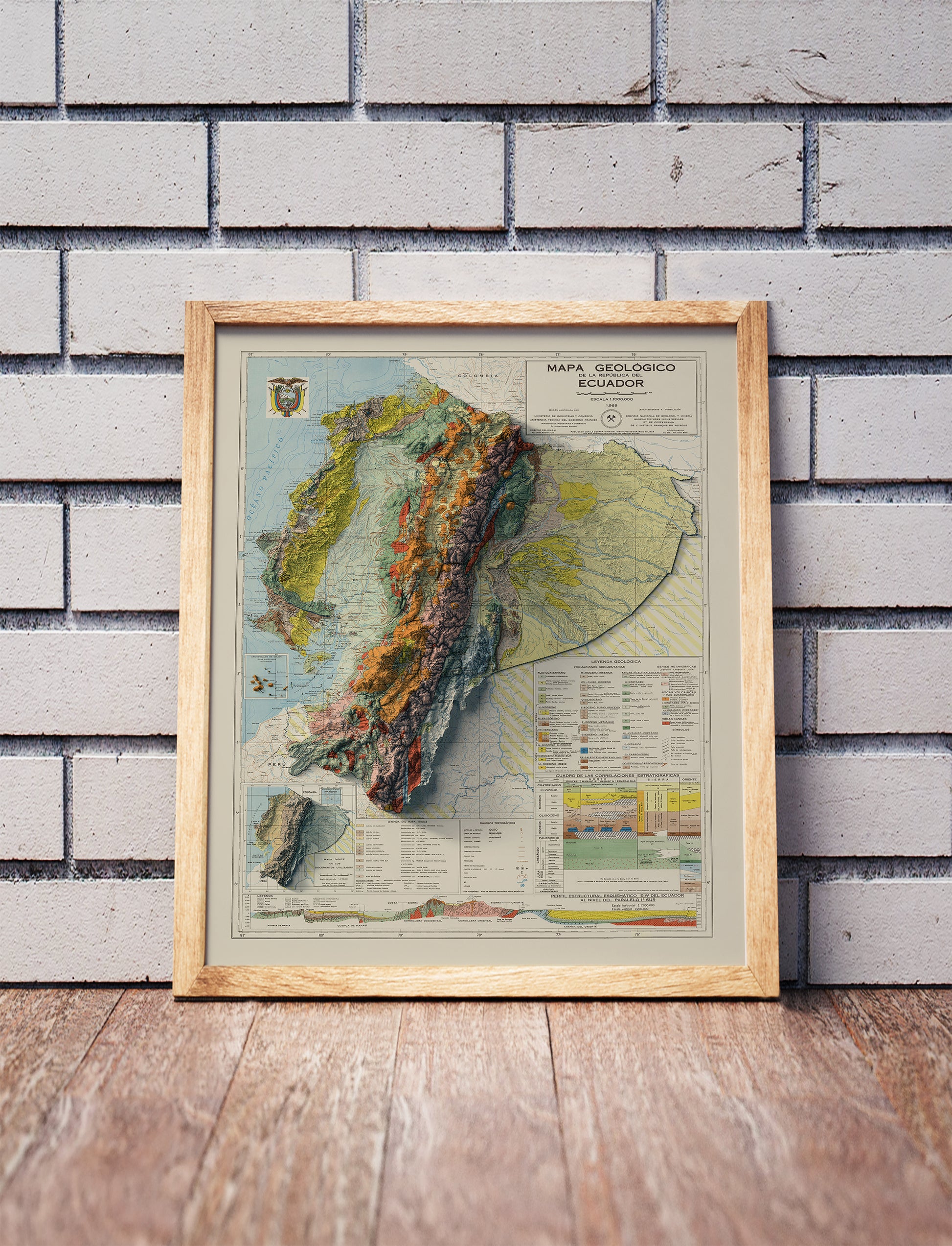 Vintage Ecuador shaded relief map in a wooden frame. Realistic terrain art print for home decor, displayed against a brick wall