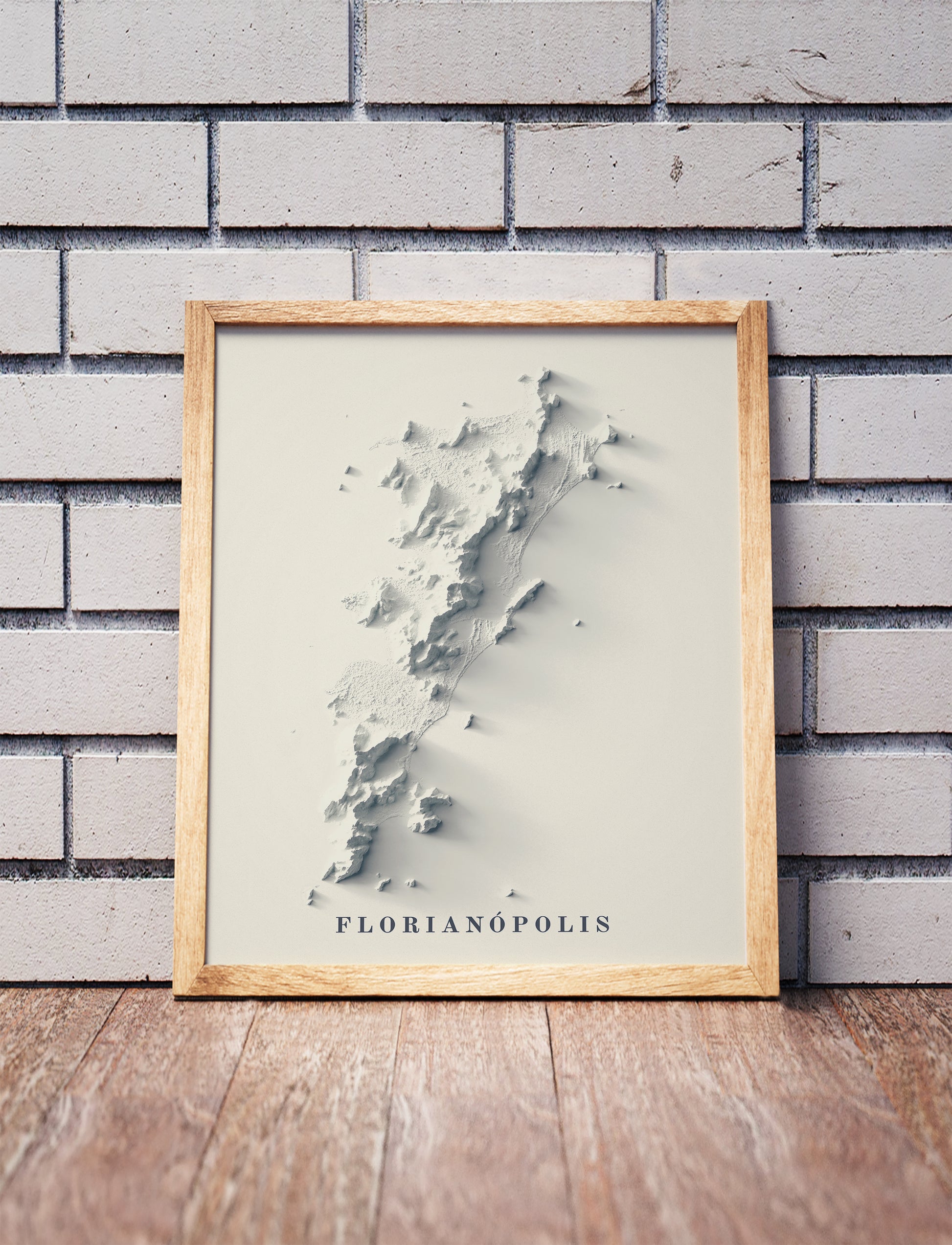 Vintage Florianopolis (Brazil) shaded relief map in a wooden frame. Realistic terrain art print for home decor, displayed against a brick wall