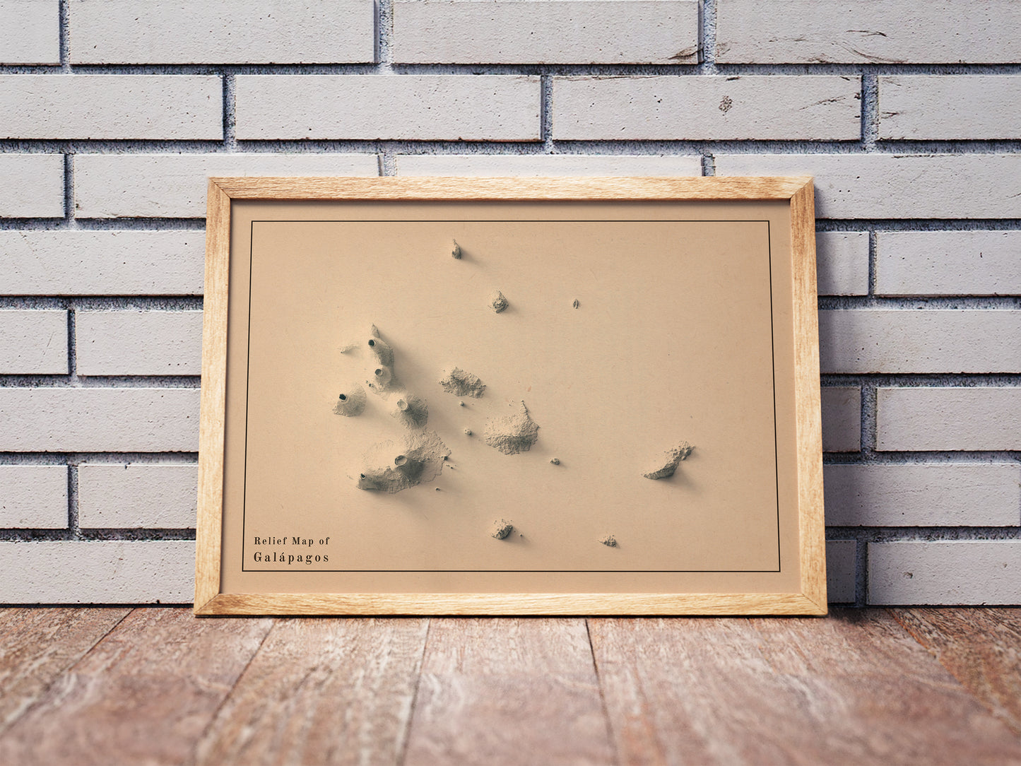 Vintage Galapagos (Ecuador) shaded relief map in a wooden frame. Realistic terrain art print for home decor, displayed against a brick wall