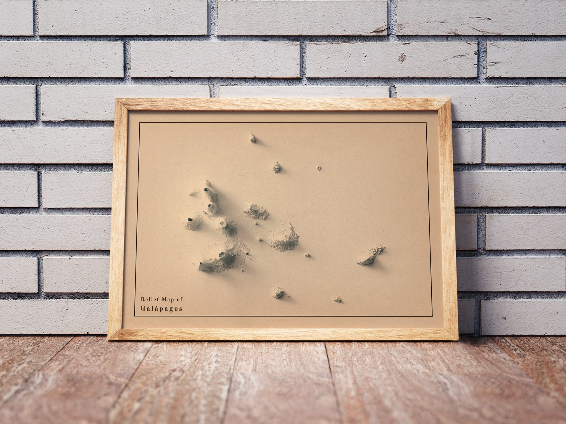 Vintage Galapagos (Ecuador) shaded relief map in a wooden frame. Realistic terrain art print for home decor, displayed against a brick wall