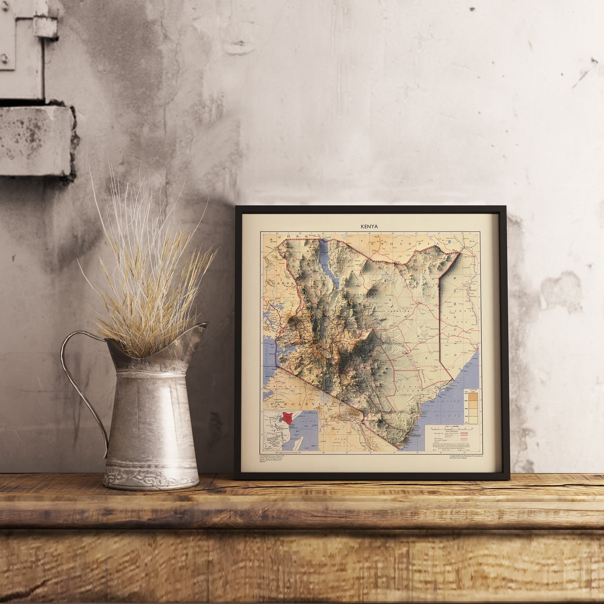 Kenya shaded relief map in black frame. Realistic terrain art print for home decor, displayed on rustic wooden table