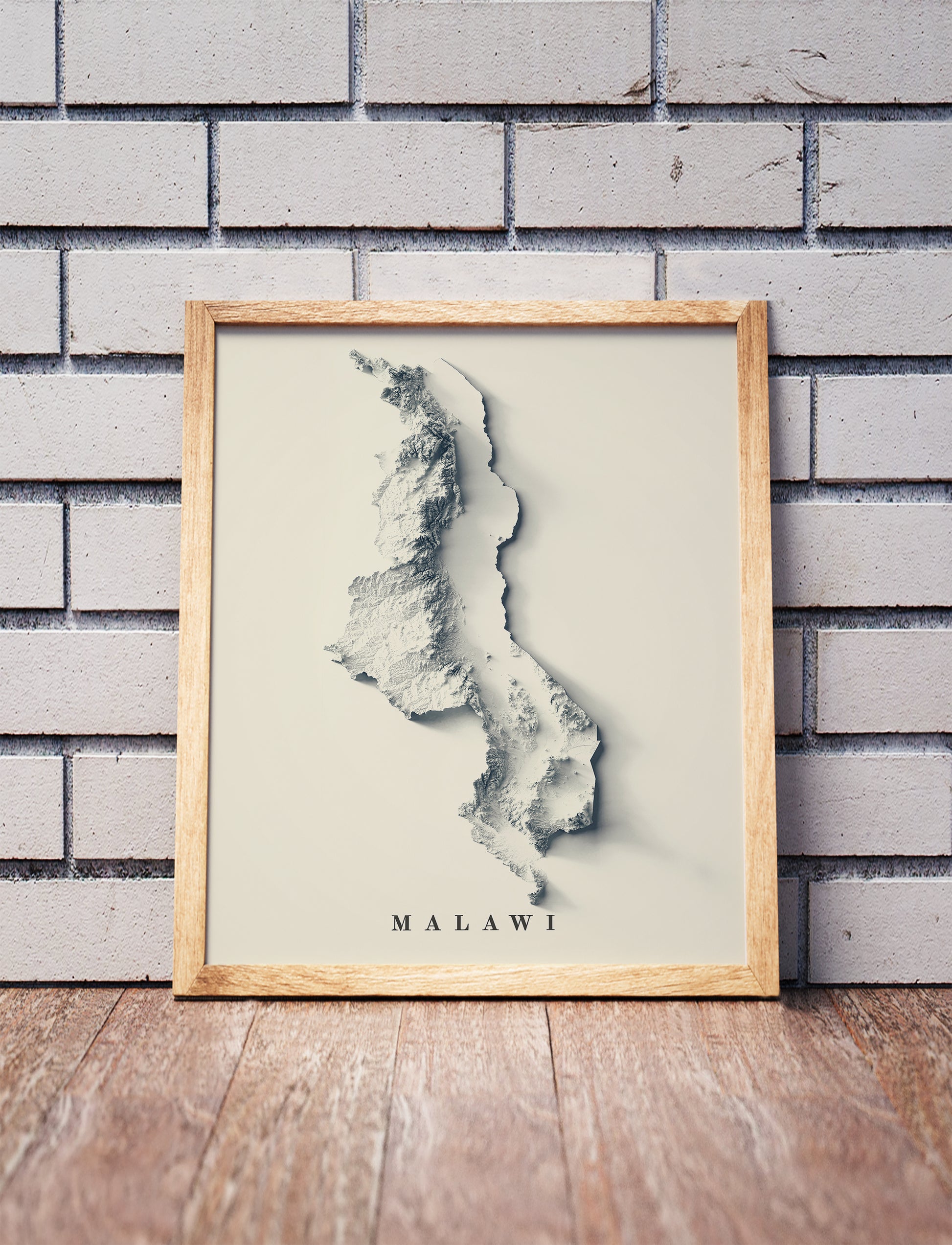 Vintage Malawi shaded relief map in a wooden frame. Realistic terrain art print for home decor, displayed against a brick wall