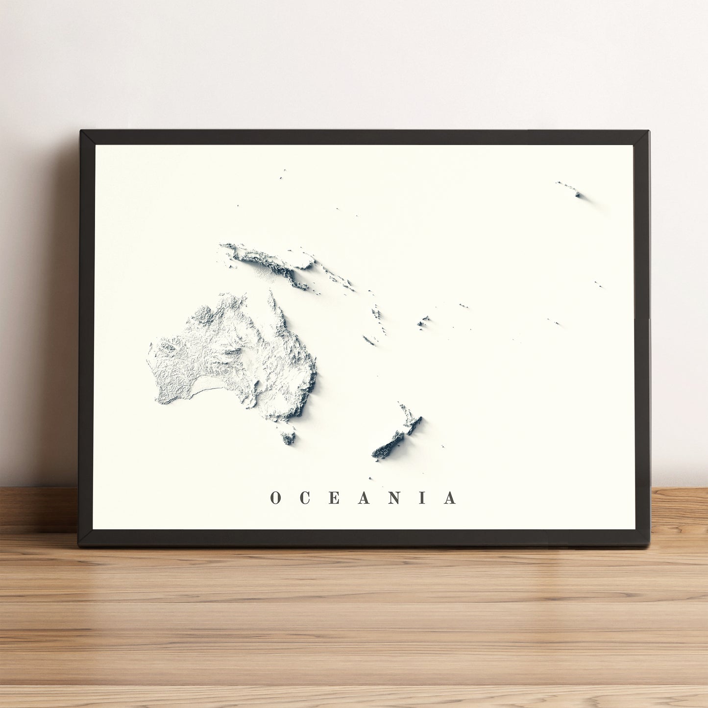 Oceania framed shaded relief map in black frame. Artistic print highlighting mountains with a realistic terrain effect