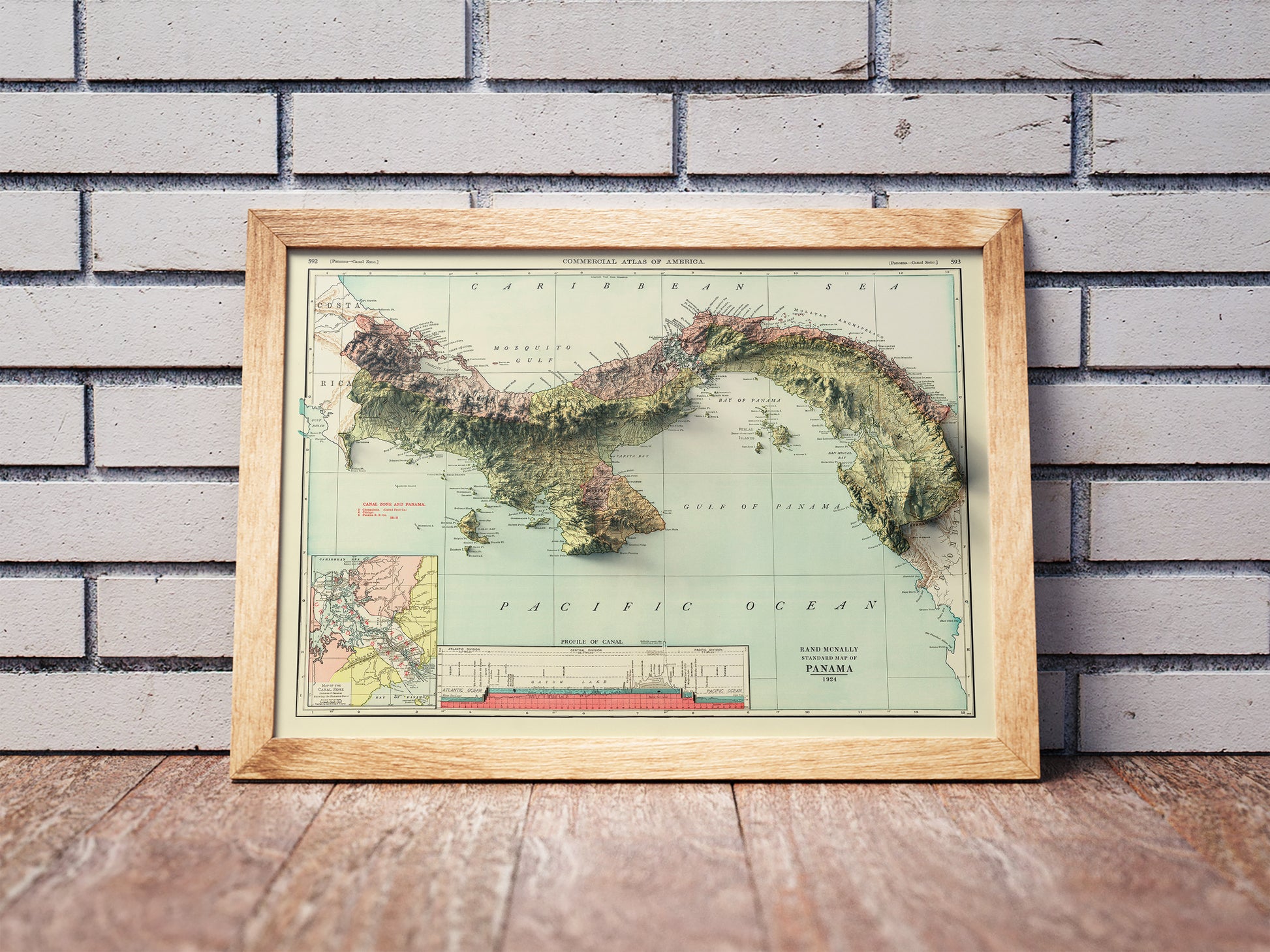 Vintage Panama shaded relief map in a wooden frame. Realistic terrain art print for home decor, displayed against a brick wall