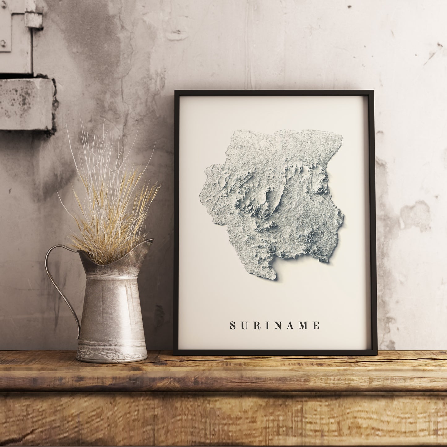 Suriname shaded relief map in black frame. Realistic terrain art print for home decor, displayed on rustic wooden table