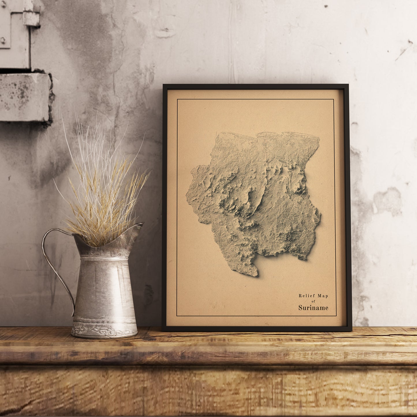 Vintage Suriname shaded relief map in black frame. Realistic terrain art print for home decor, displayed on rustic wooden table