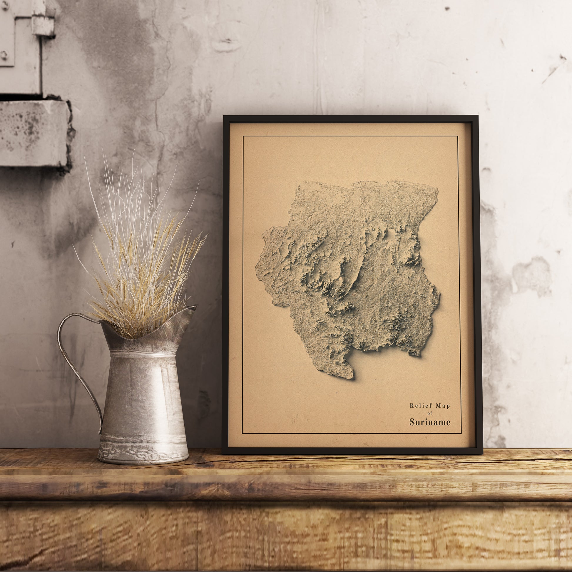 Vintage Suriname shaded relief map in black frame. Realistic terrain art print for home decor, displayed on rustic wooden table