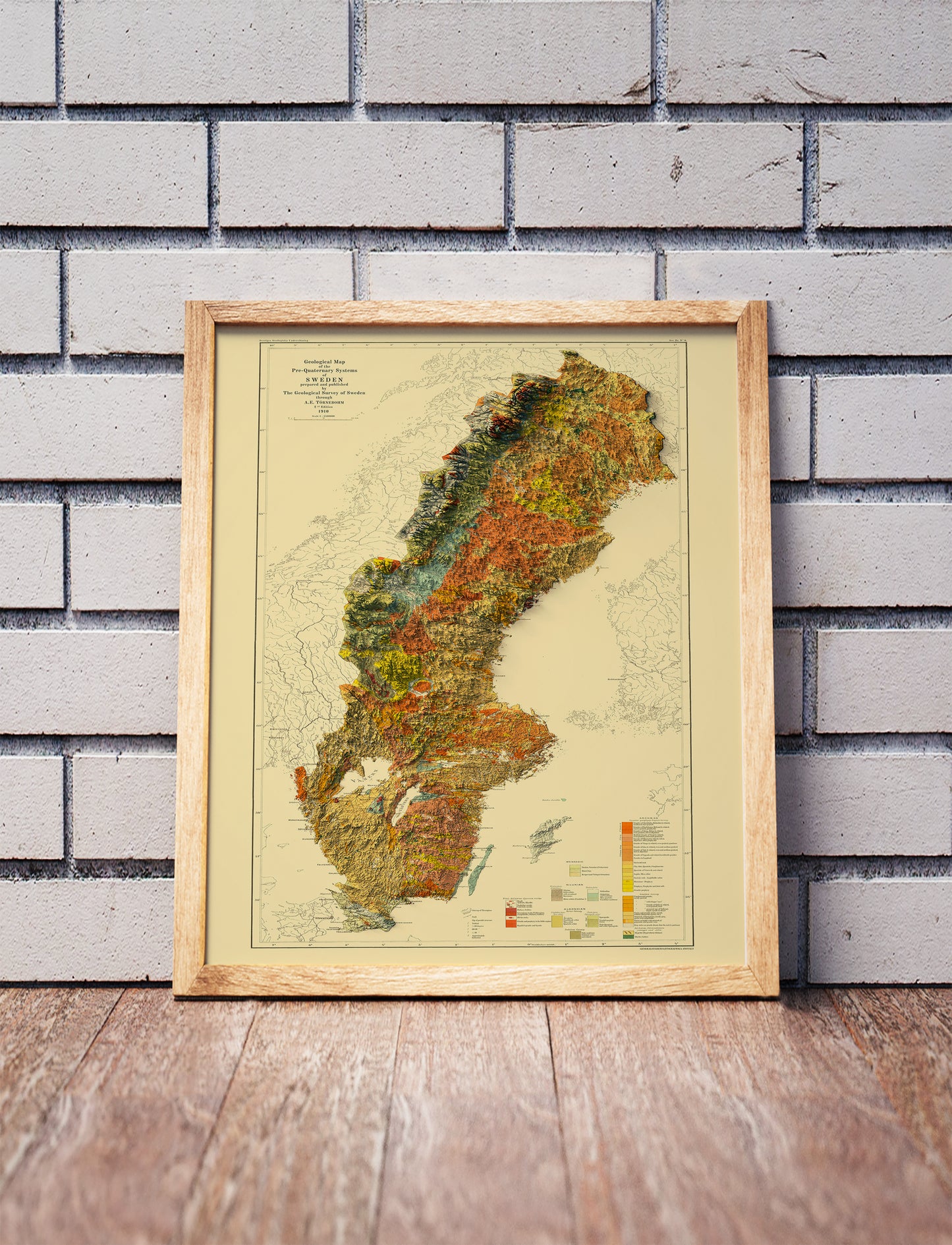 Vintage Sweden shaded relief map in a wooden frame. Realistic terrain art print for home decor, displayed against a brick wall