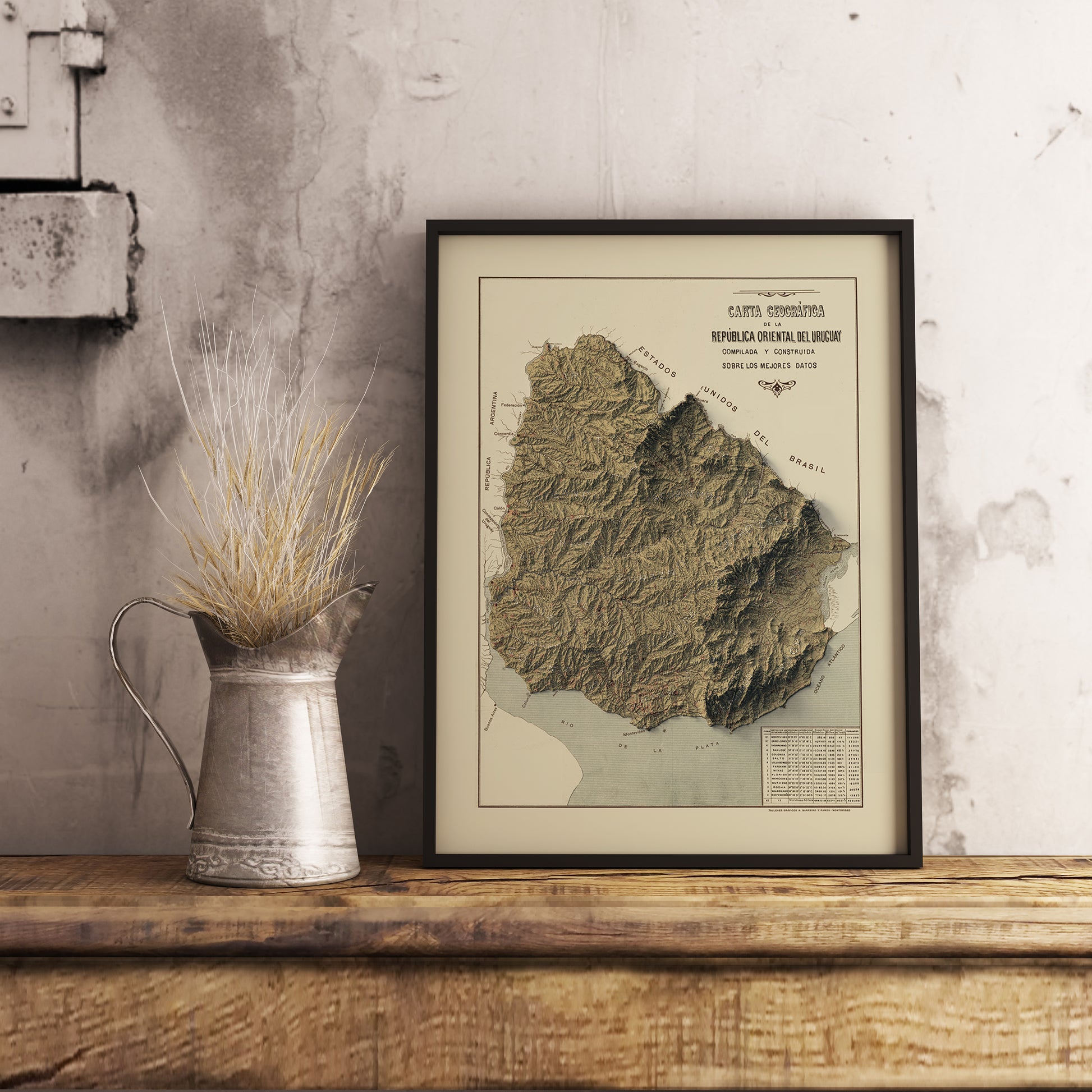 Vintage Uruguay shaded relief map in black frame. Realistic terrain art print for home decor, displayed on rustic wooden table