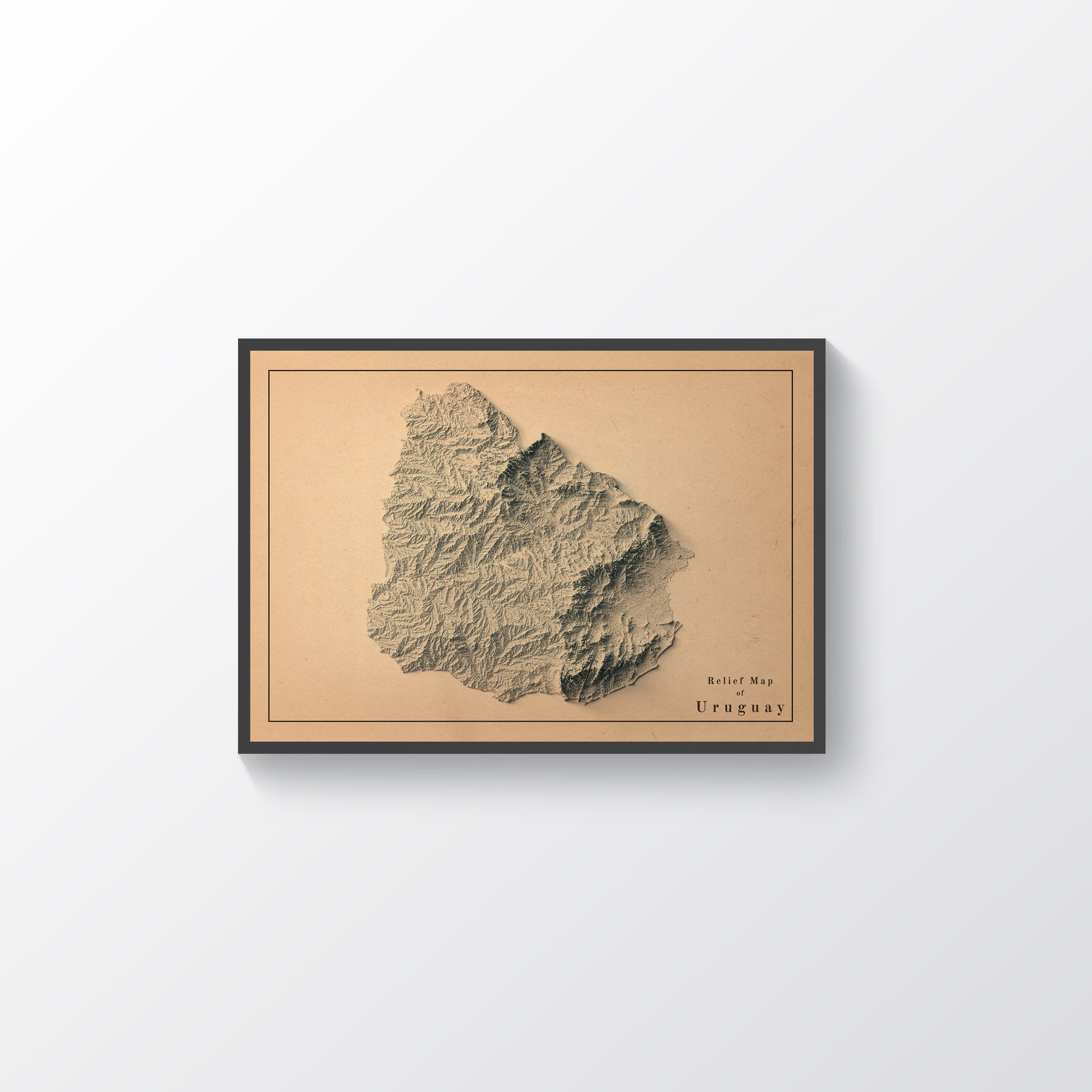 Vintage Uruguay shaded relief map in black frame. Realistic terrain art print for home decor, displayed on rustic wooden table