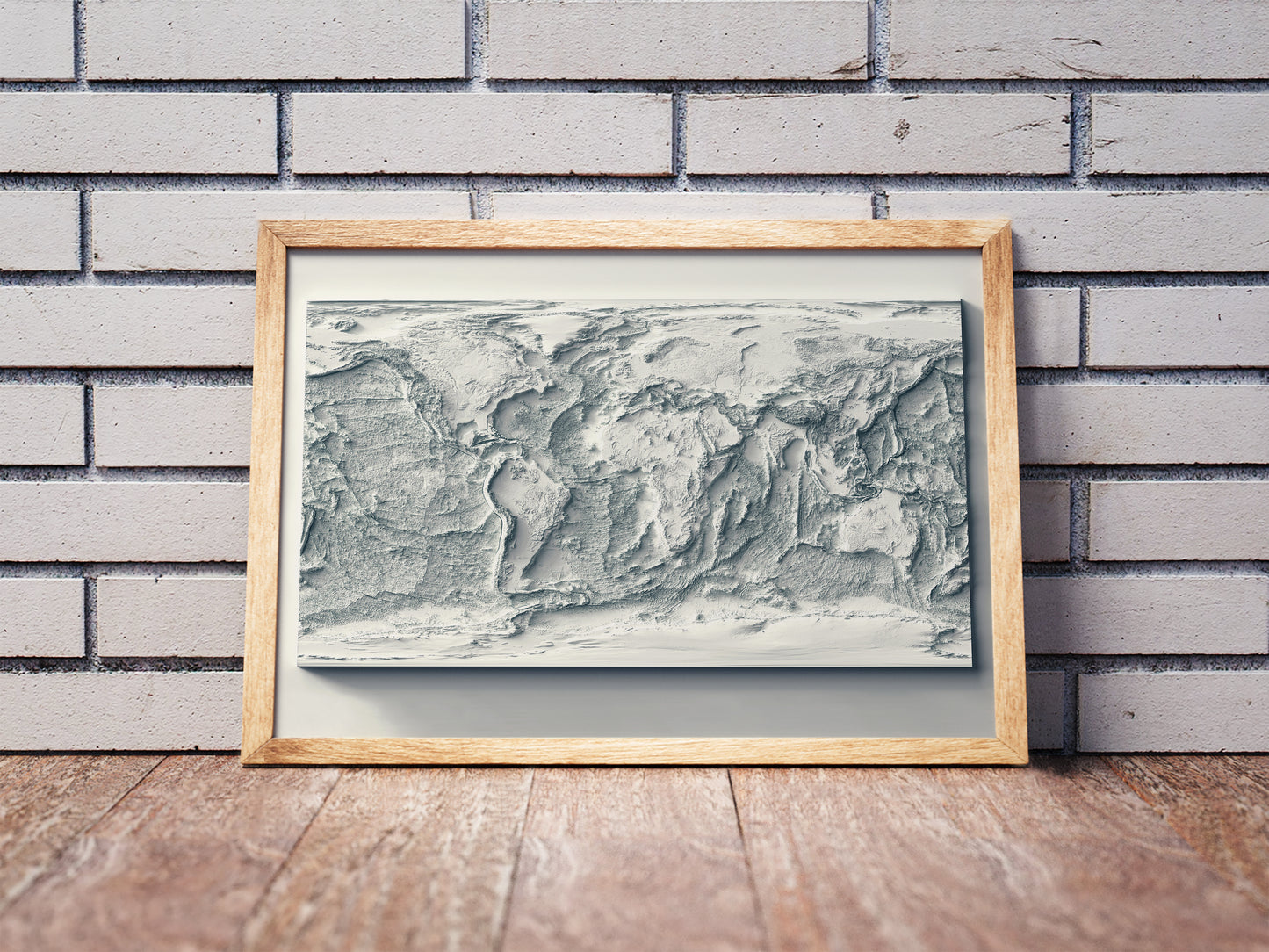 World Bathymetric shaded relief map in a wooden frame. Realistic terrain art print for home decor, displayed against a brick wall