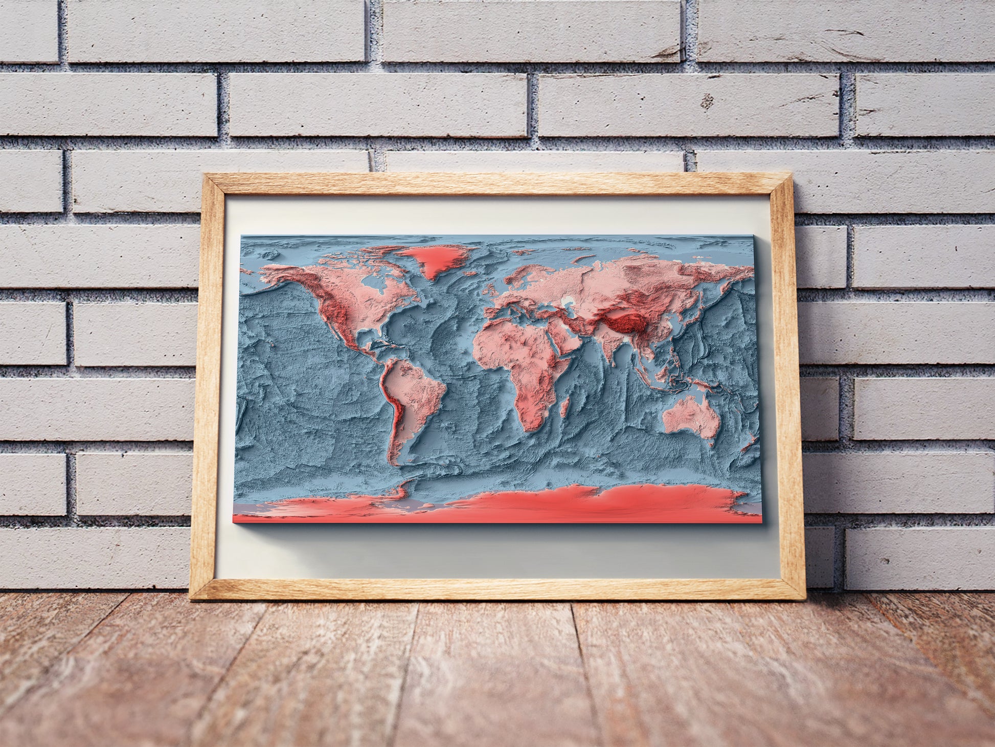 World Bathymetric shaded relief map in a wooden frame. Realistic terrain art print for home decor, displayed against a brick wall