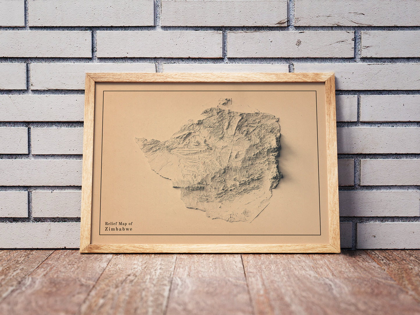 Vintage Zimbabwe shaded relief map in a wooden frame. Realistic terrain art print for home decor, displayed against a brick wall