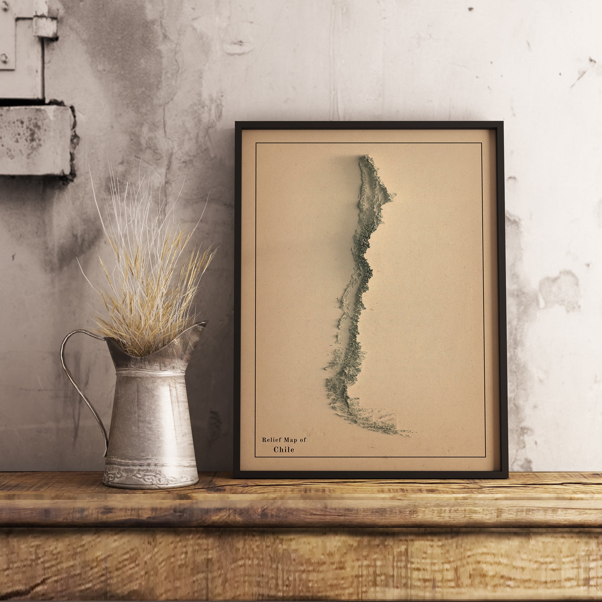 Vintage Chile shaded relief map in black frame. Realistic terrain art print for home decor, displayed on rustic wooden table