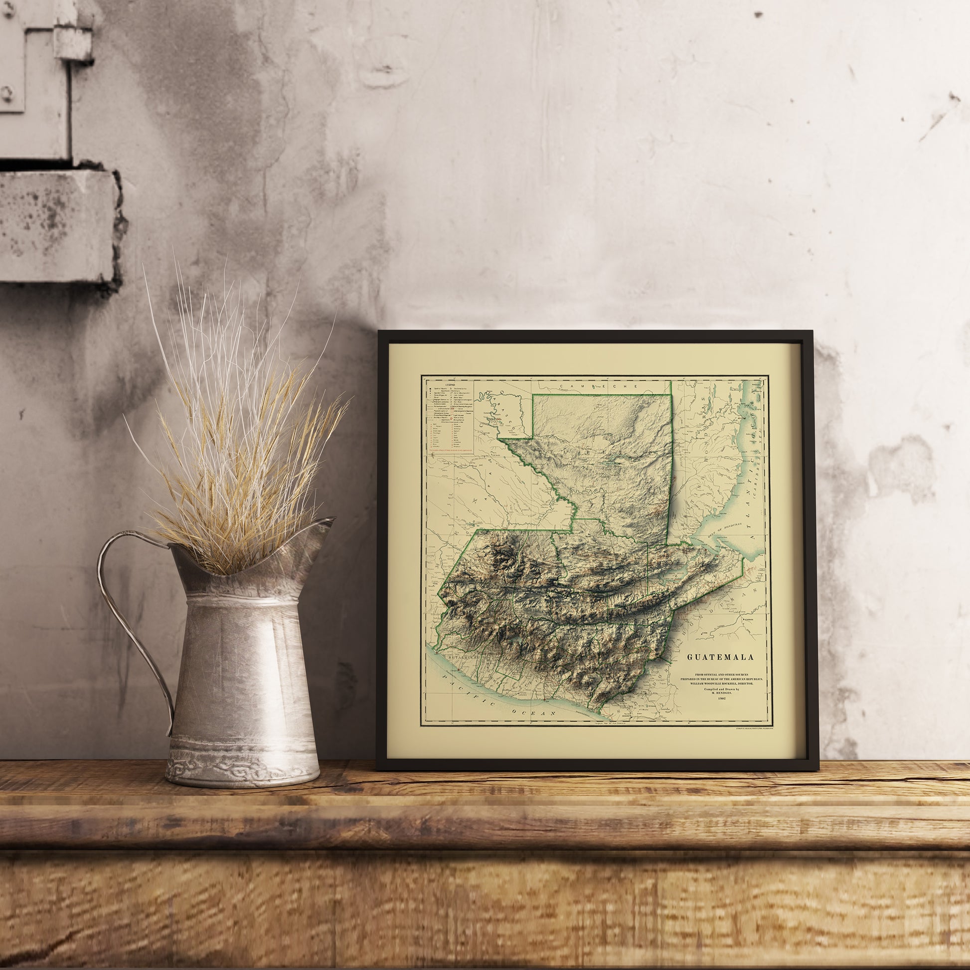 Vintage Guatemala shaded relief map in black frame. Realistic terrain art print for home decor, displayed on rustic wooden table