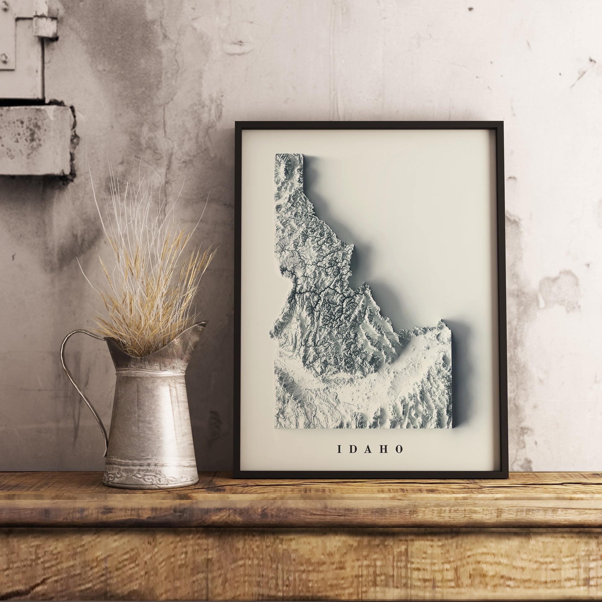 Idaho (USA) shaded relief map in black frame. Realistic terrain art print for home decor, displayed on rustic wooden table