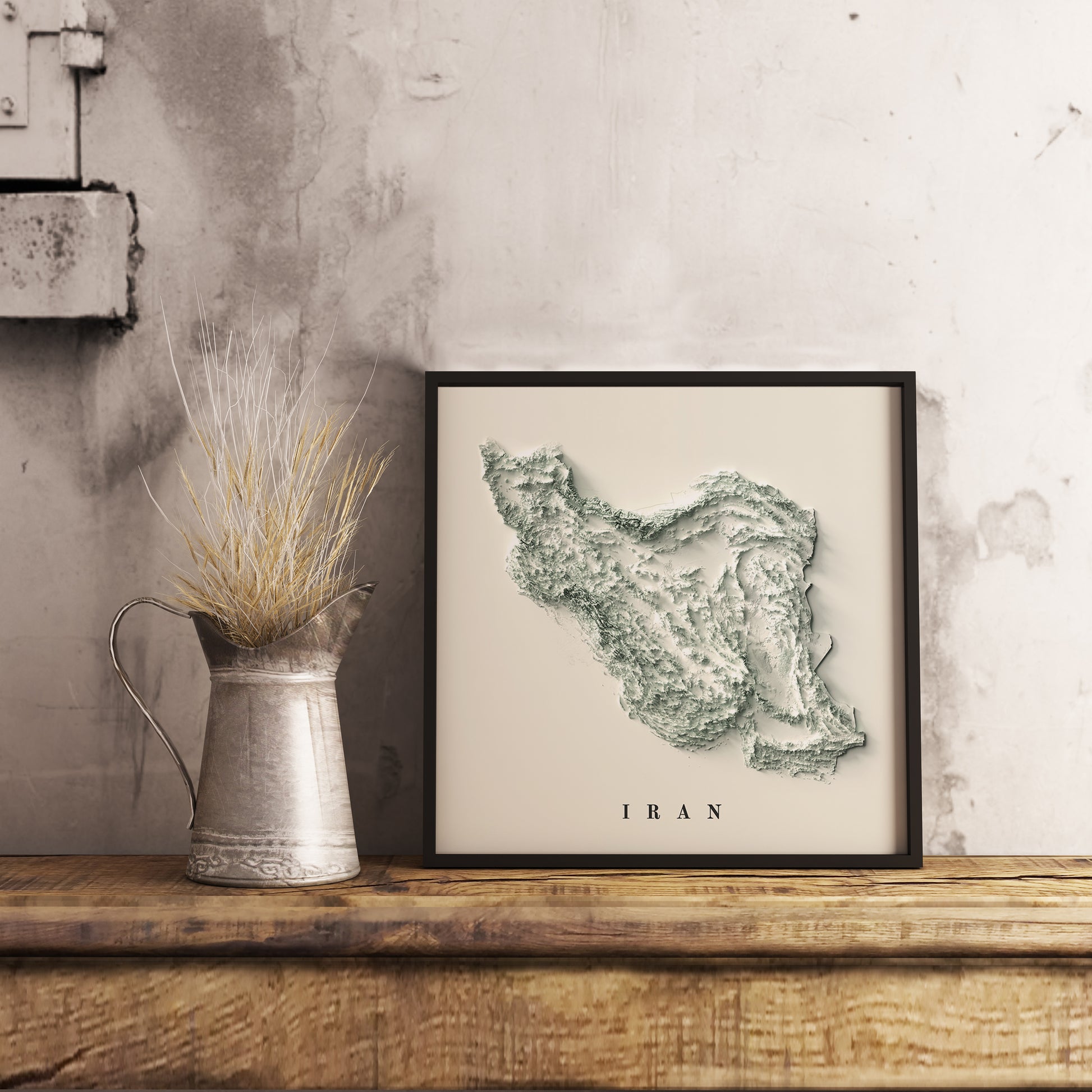 Vintage Iran shaded relief map in black frame. Realistic terrain art print for home decor, displayed on rustic wooden table