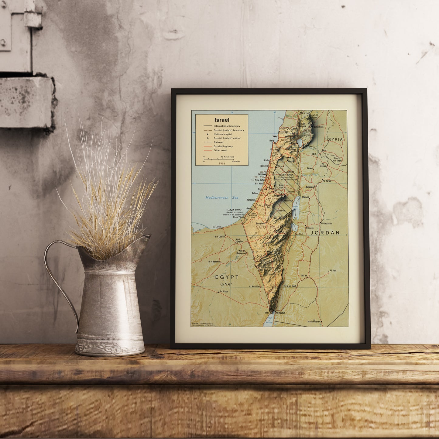 Vintage Israel shaded relief map in black frame. Realistic terrain art print for home decor, displayed on rustic wooden table