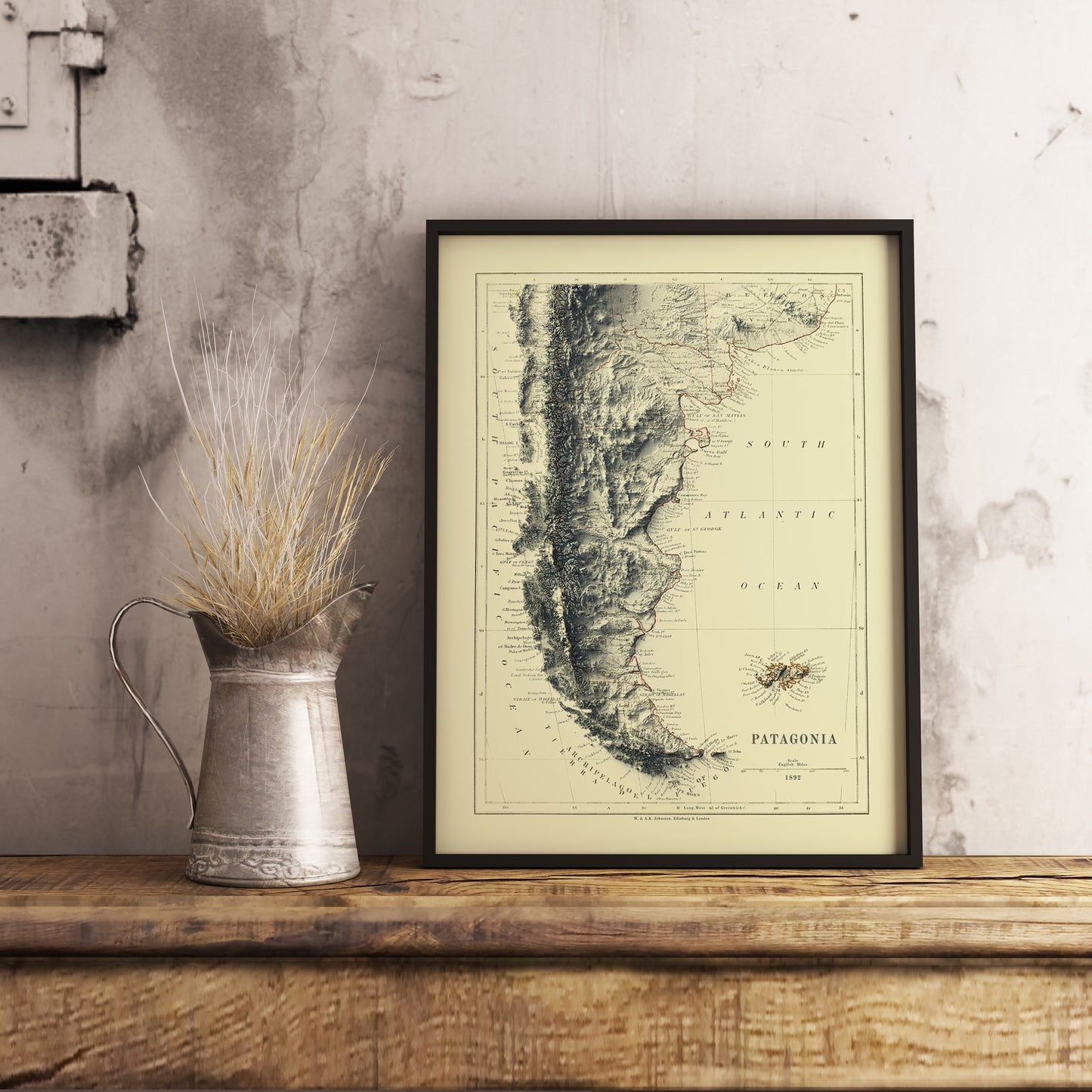 Vintage Patagonia shaded relief map in black frame. Realistic terrain art print for home decor, displayed on rustic wooden table
