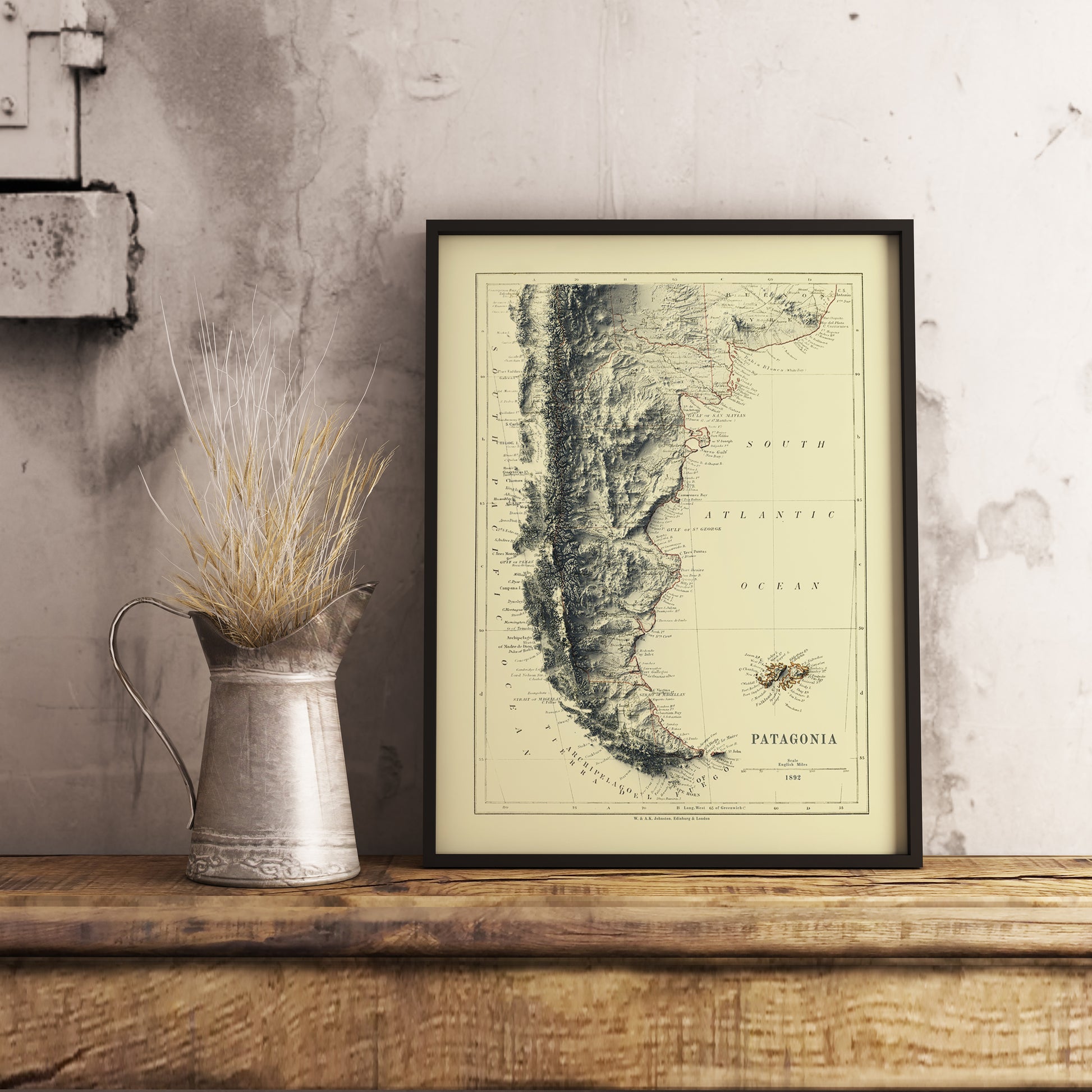 Vintage Patagonia shaded relief map in black frame. Realistic terrain art print for home decor, displayed on rustic wooden table