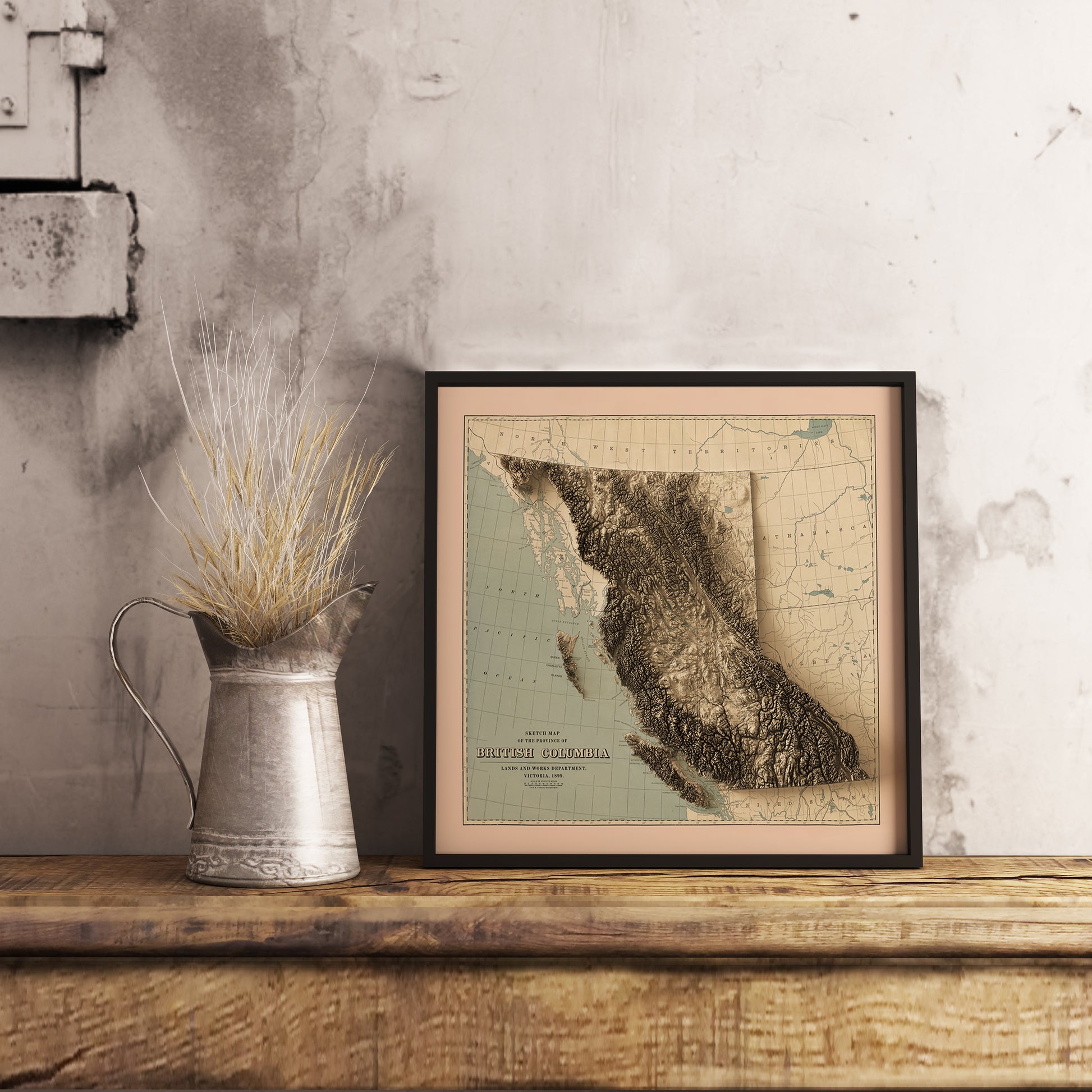 Vintage British Columbia (Canada) shaded relief map in black frame. Realistic terrain art print for home decor, displayed on rustic wooden table