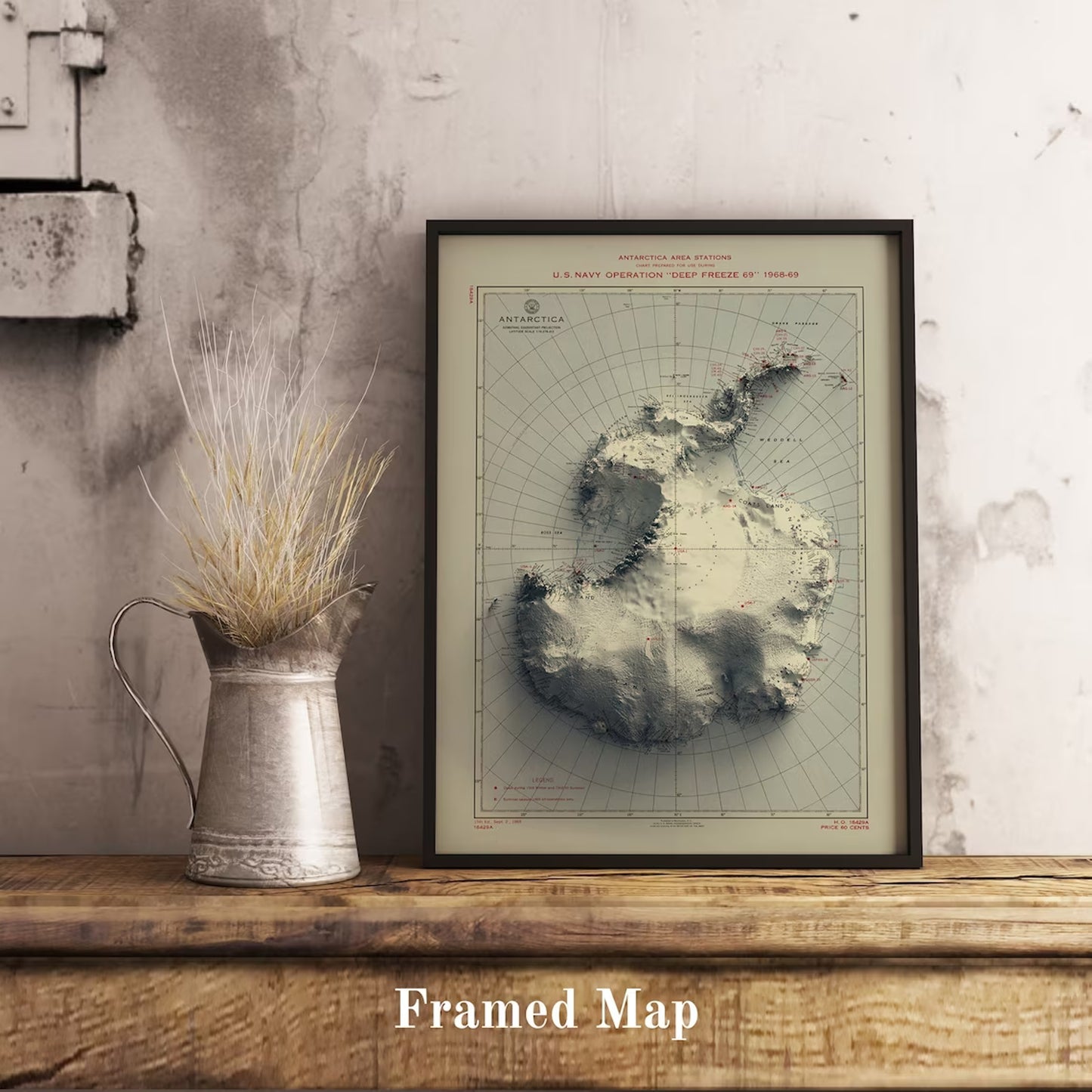 Vintage Antartctic shaded relief map in black frame. Realistic terrain art print for home decor, displayed on rustic wooden table