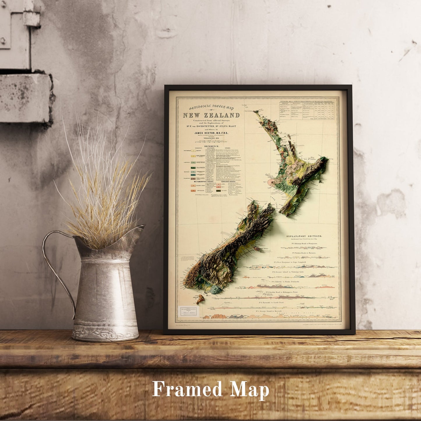 Vintage New Zealand shaded relief map in black frame. Realistic terrain art print for home decor, displayed on rustic wooden table