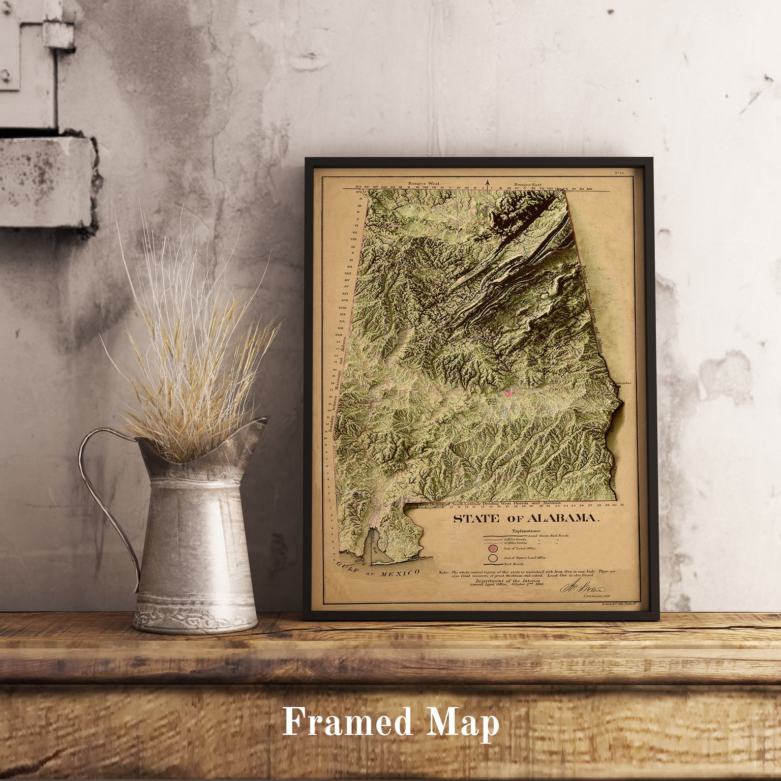 Vintage Alabama (USA) shaded relief map in black frame. Realistic terrain art print for home decor, displayed on rustic wooden table