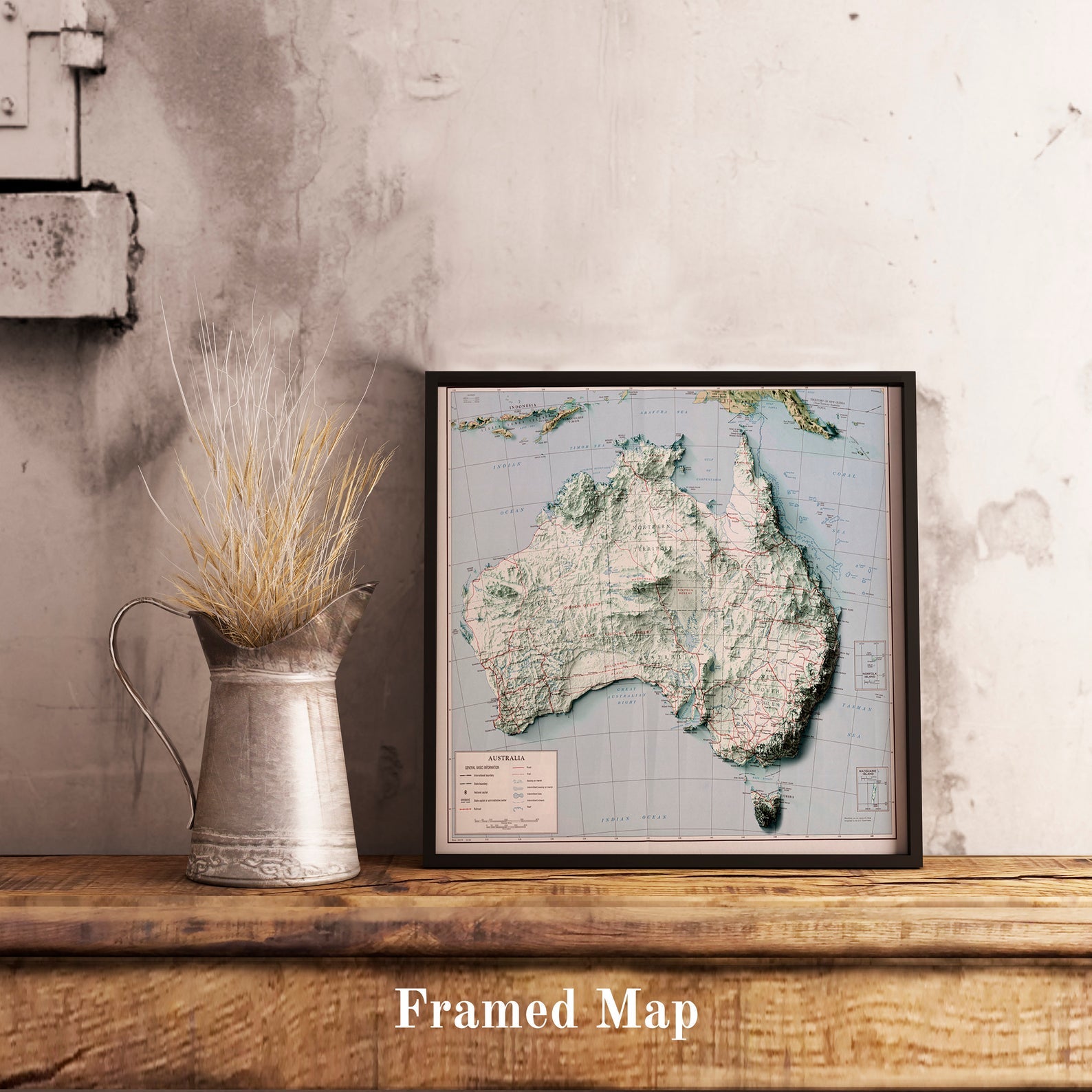 Vintage Australia shaded relief map in black frame. Realistic terrain art print for home decor, displayed on rustic wooden table