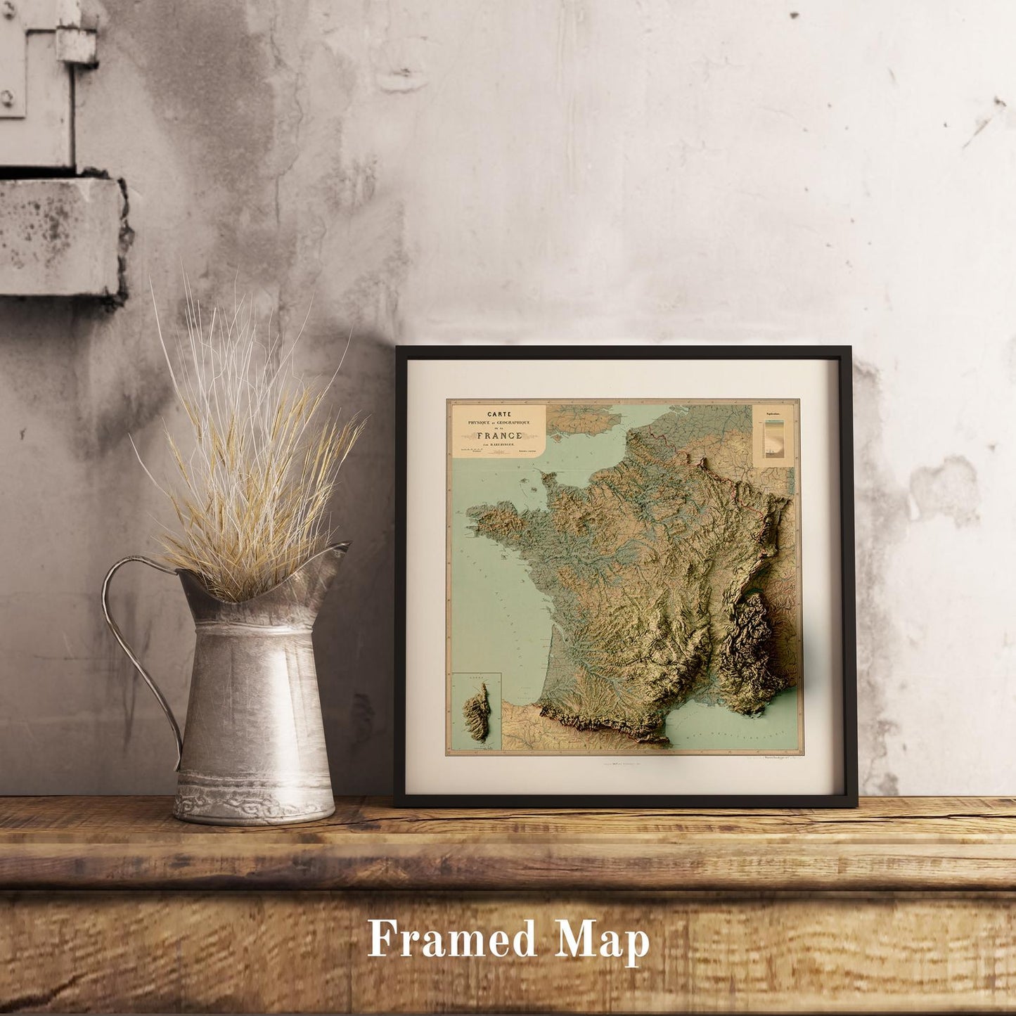 Vintage France shaded relief map in black frame. Realistic terrain art print for home decor, displayed on rustic wooden table