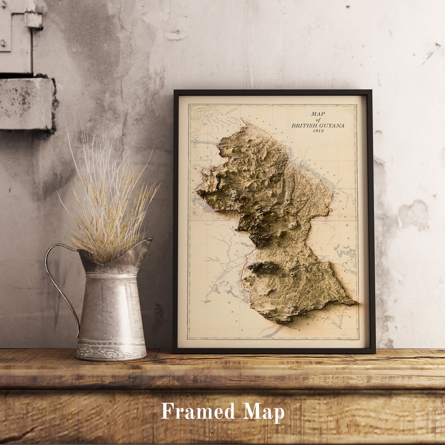 Vintage Guyana shaded relief map in black frame. Realistic terrain art print for home decor, displayed on rustic wooden table