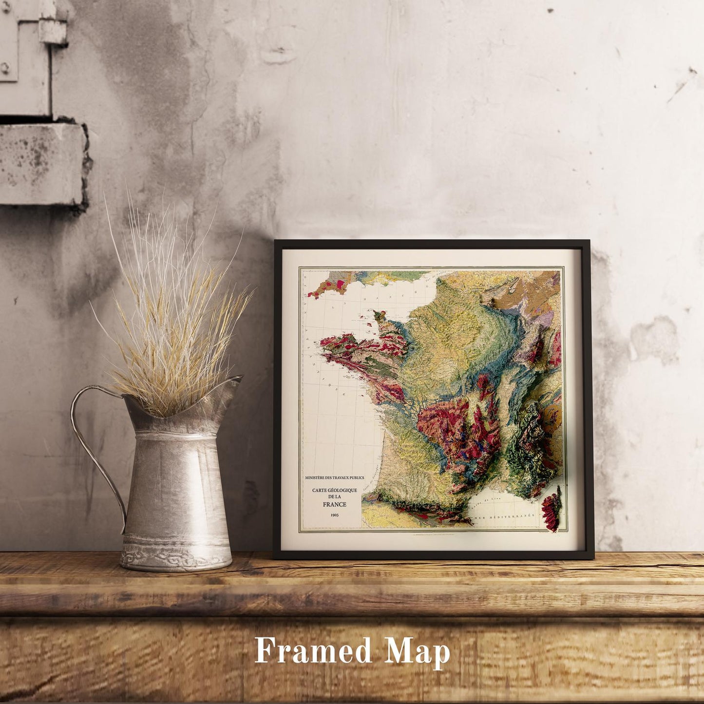 Vintage France shaded relief map in black frame. Realistic terrain art print for home decor, displayed on rustic wooden table