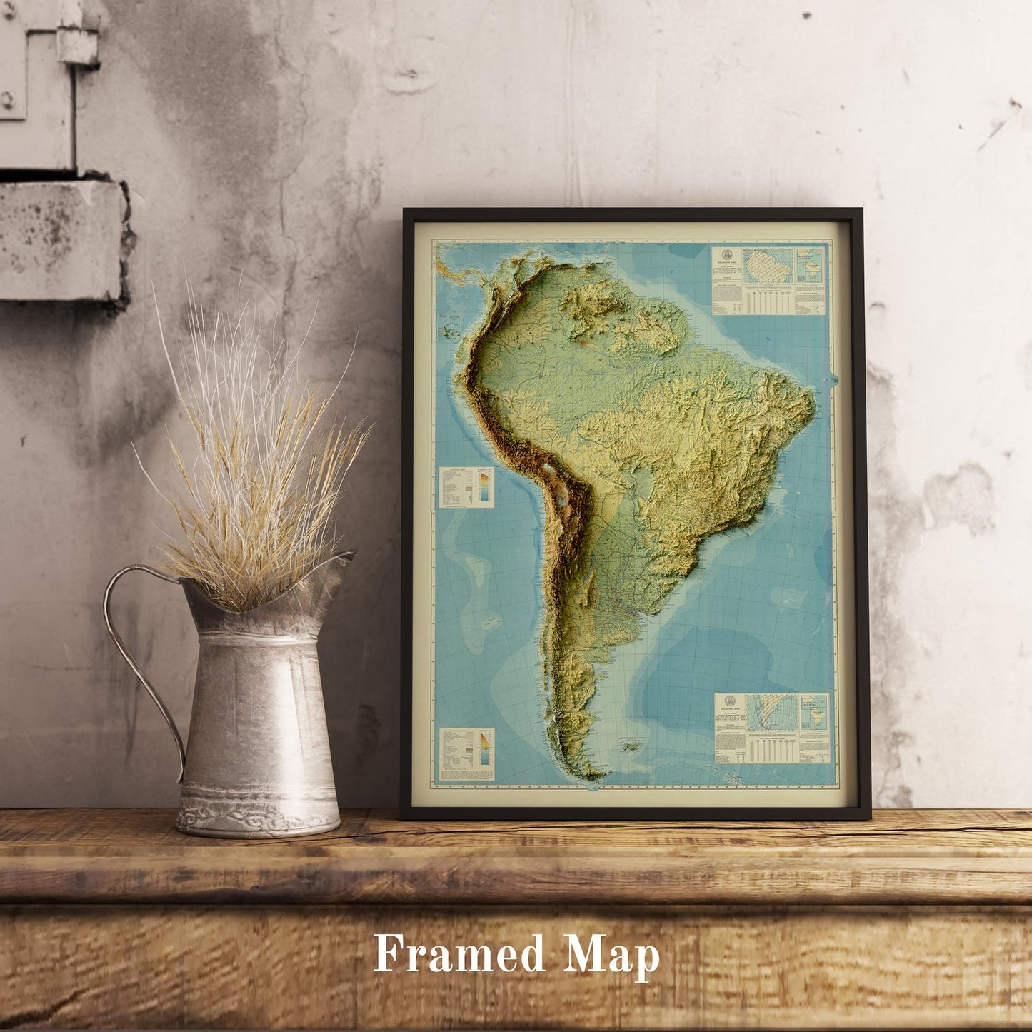 Vintage South America shaded relief map in black frame. Realistic terrain art print for home decor, displayed on rustic wooden table