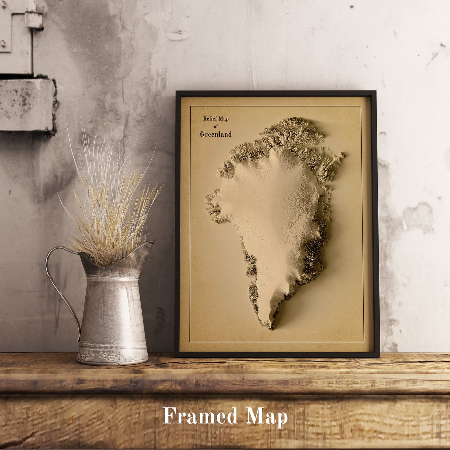 Vintage Greenland shaded relief map in black frame. Realistic terrain art print for home decor, displayed on rustic wooden table