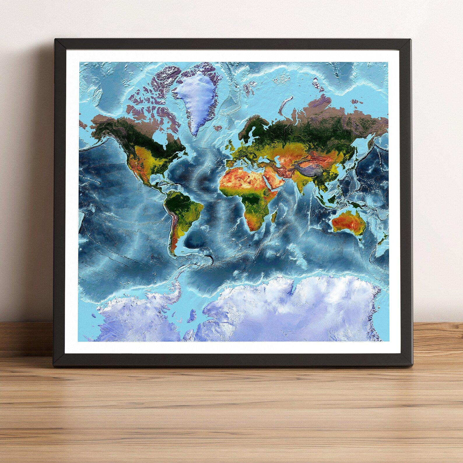 World framed shaded relief map in black frame, showing Mercator Projection. Artistic print highlighting vegetation and bathymetry