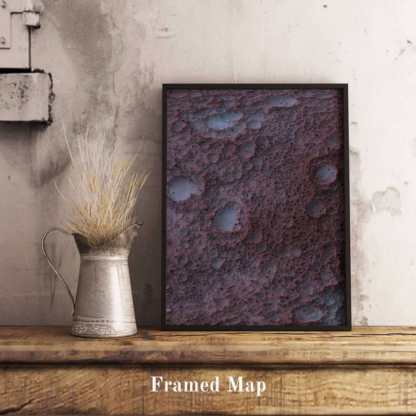 Moon shaded relief map in black frame. Realistic terrain art print for home decor, displayed on rustic wooden table