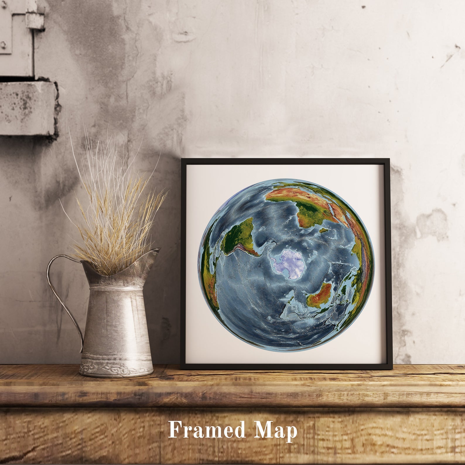 World shaded relief map in black frame, featuring the WGS 1984 Grid South Projection. Terrain art print for home decor, displayed on rustic wooden table