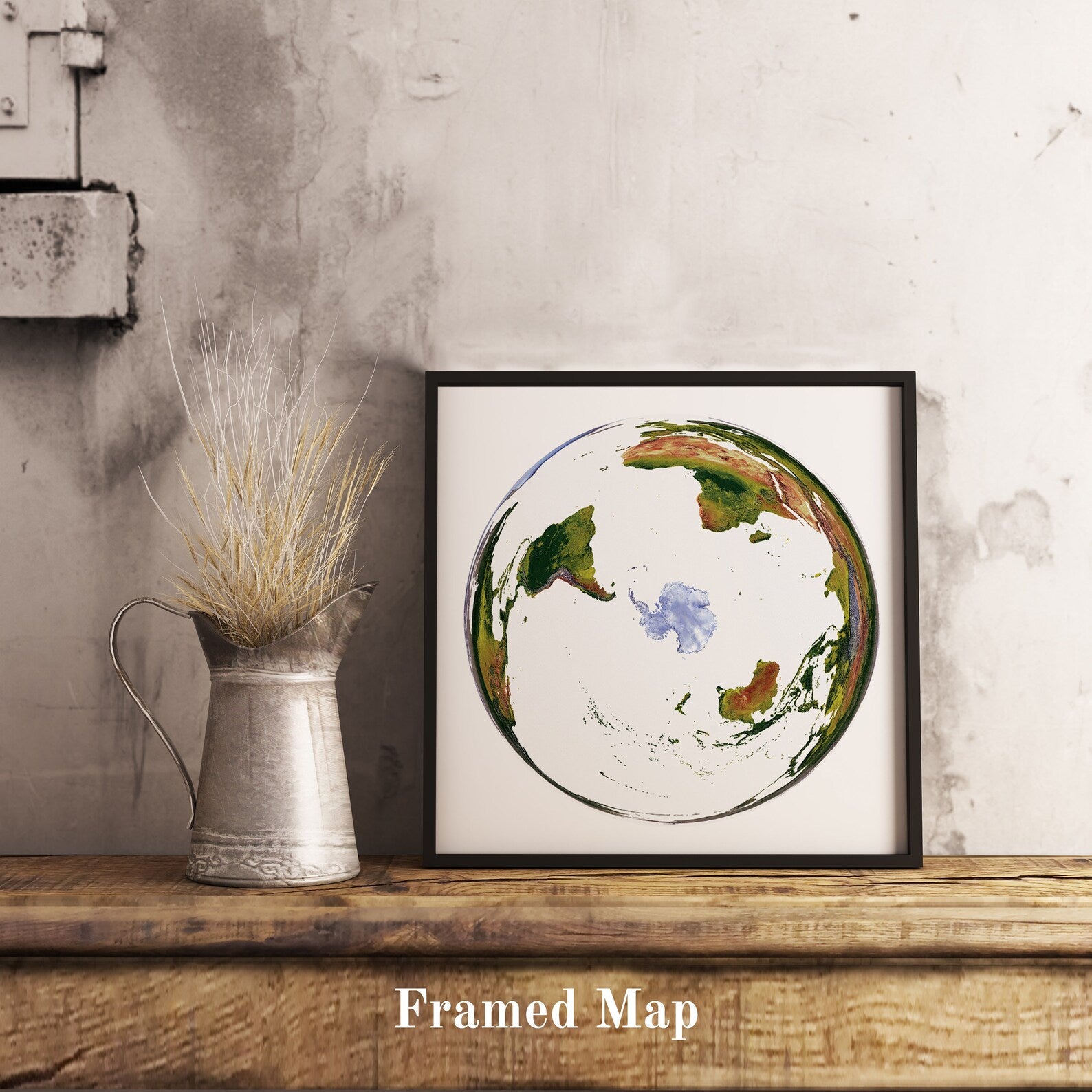 World shaded relief map in black frame, featuring the WGS 1984 Grid South Projection. Terrain art print for home decor, displayed on rustic wooden table