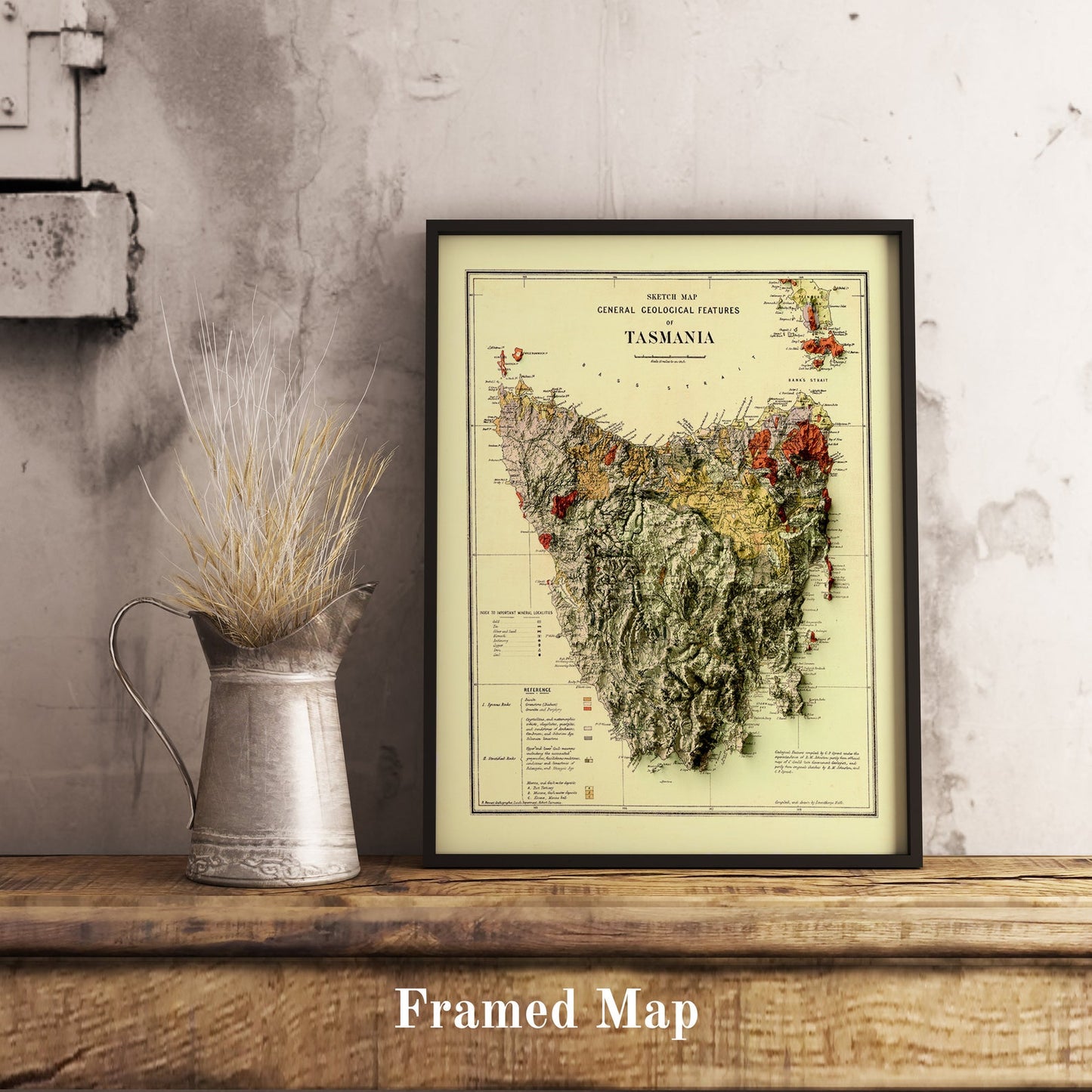 Vintage Tasmania (Australia) shaded relief map in black frame. Realistic terrain art print for home decor, displayed on rustic wooden table