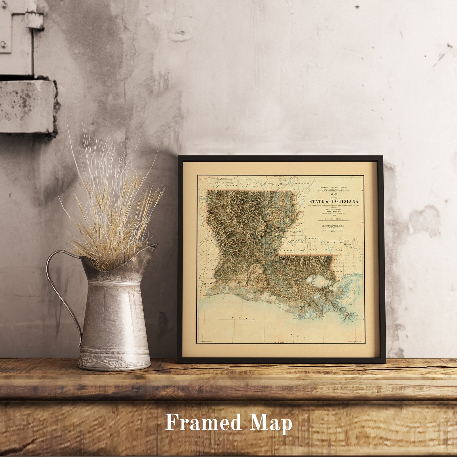 Vintage Louisiana shaded relief map in black frame. Realistic terrain art print for home decor, displayed on rustic wooden table