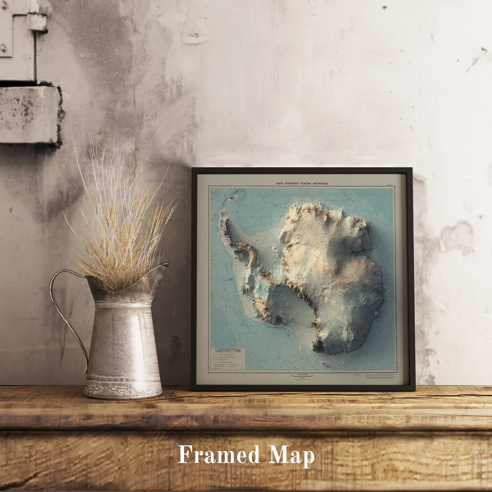 Vintage Antartctic shaded relief map in black frame. Realistic terrain art print for home decor, displayed on rustic wooden table